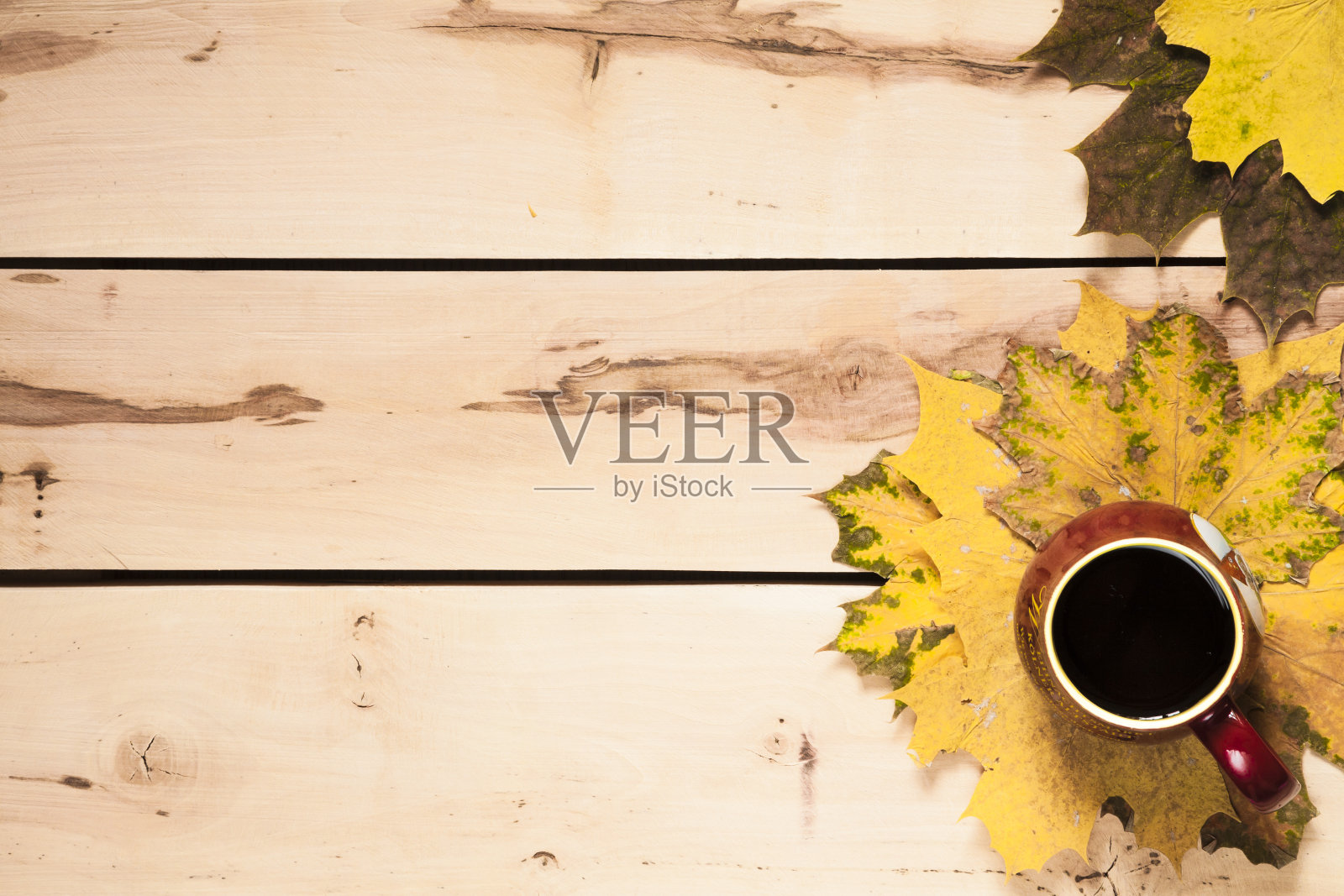 秋天的背景。桌上放着一杯咖啡和树叶照片摄影图片