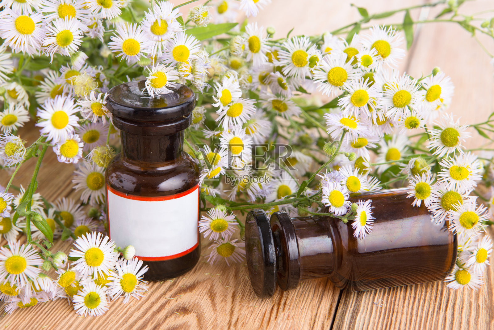 在装有甘菊花的玻璃瓶里滴一滴油照片摄影图片