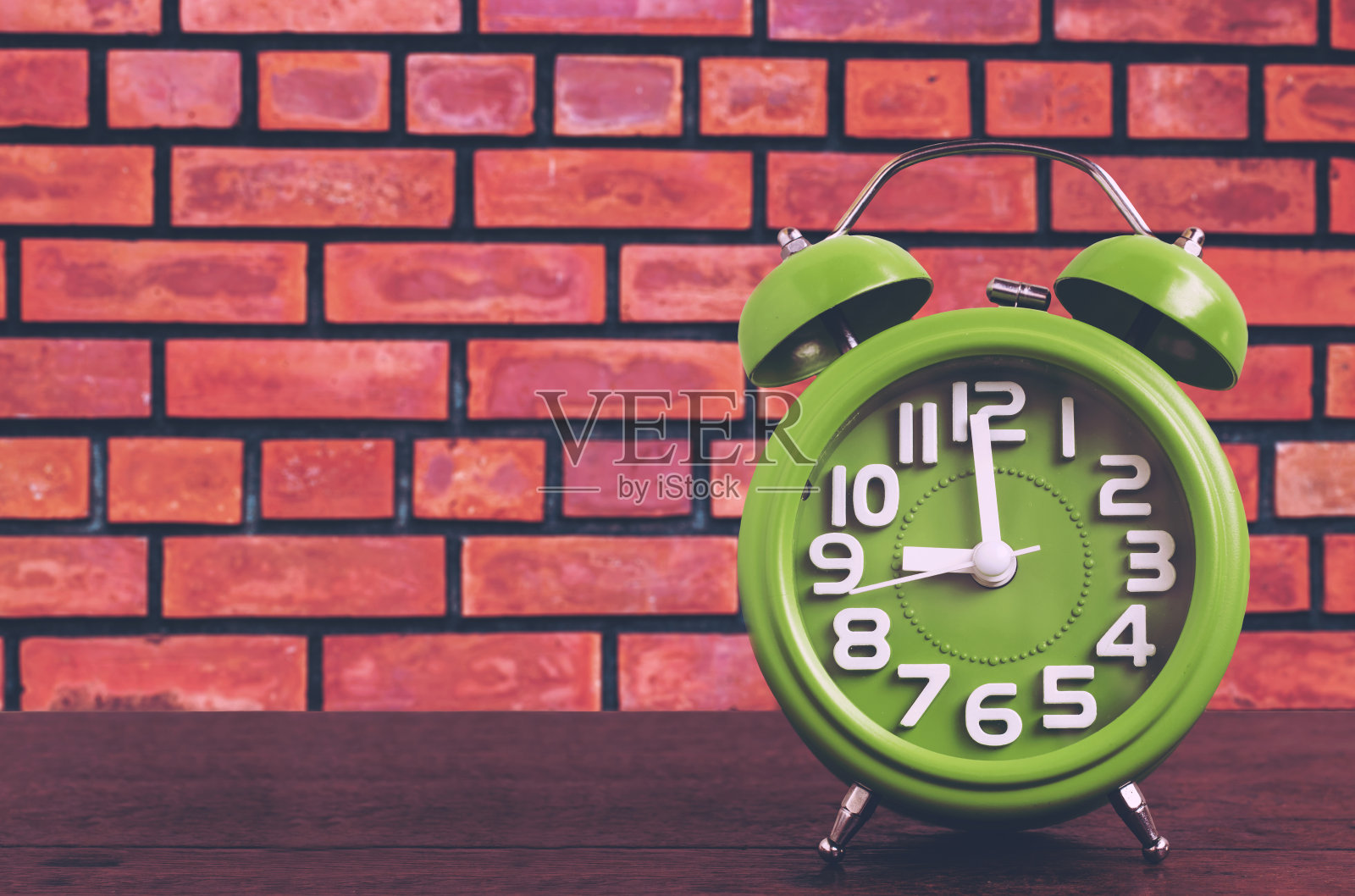 木地板上的时钟，砖墙背景，复古风格照片摄影图片