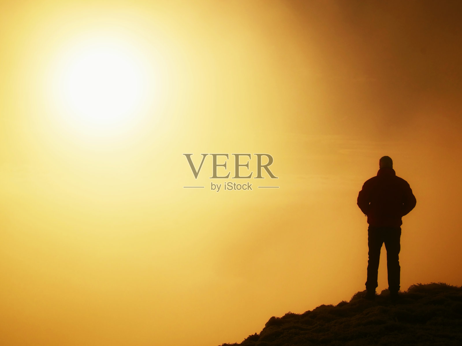 高大的徒步旅行者在世界的顶峰。浓重的雾气照片摄影图片