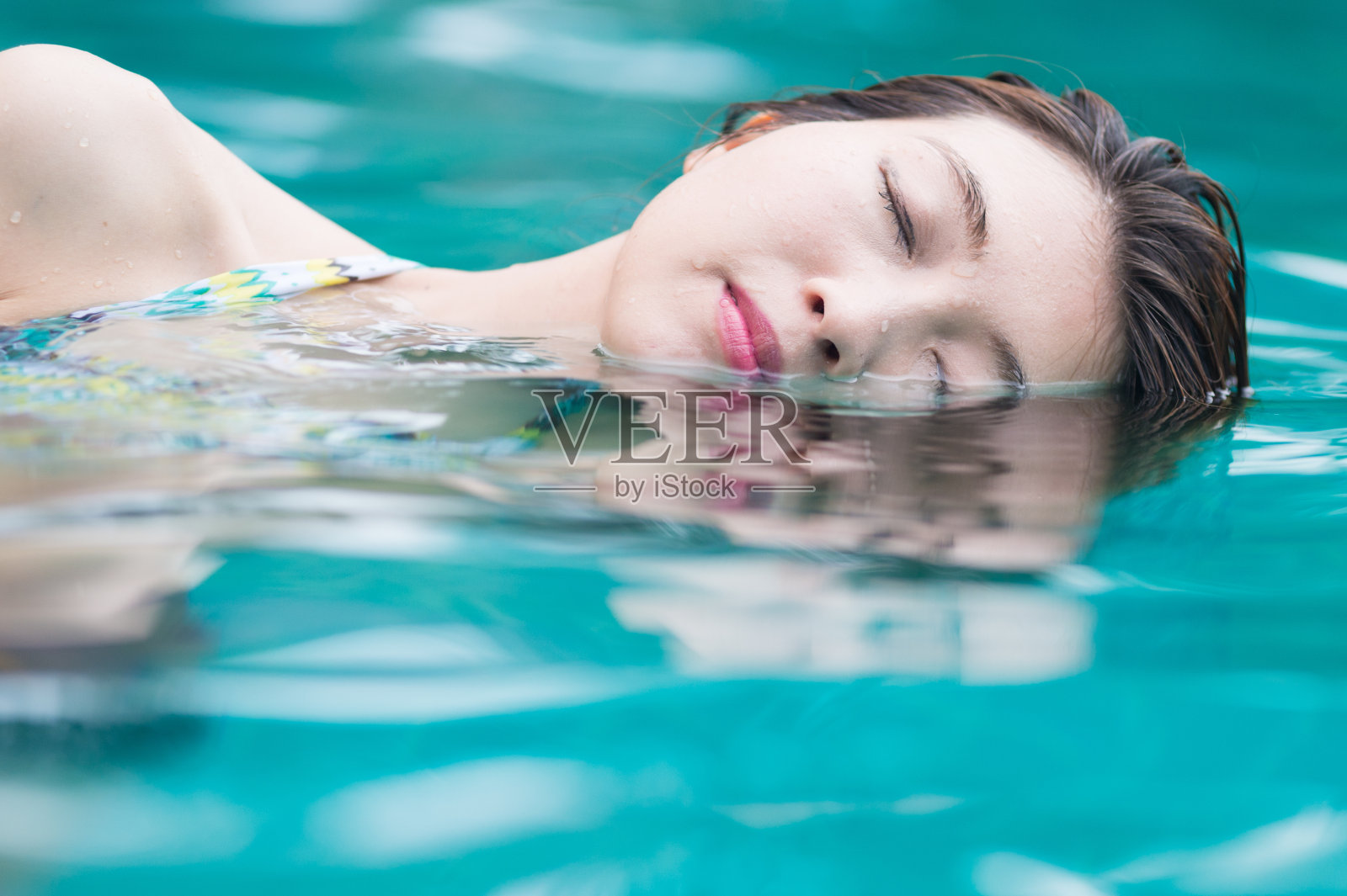 游泳池里的年轻女子照片摄影图片