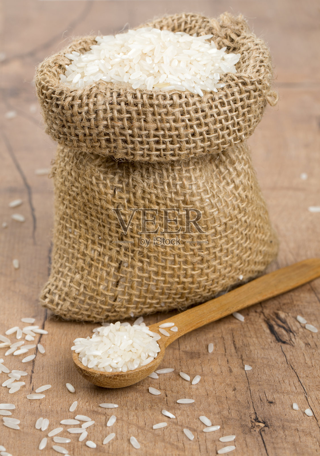 粗麻袋里的大米放在木头表面上照片摄影图片