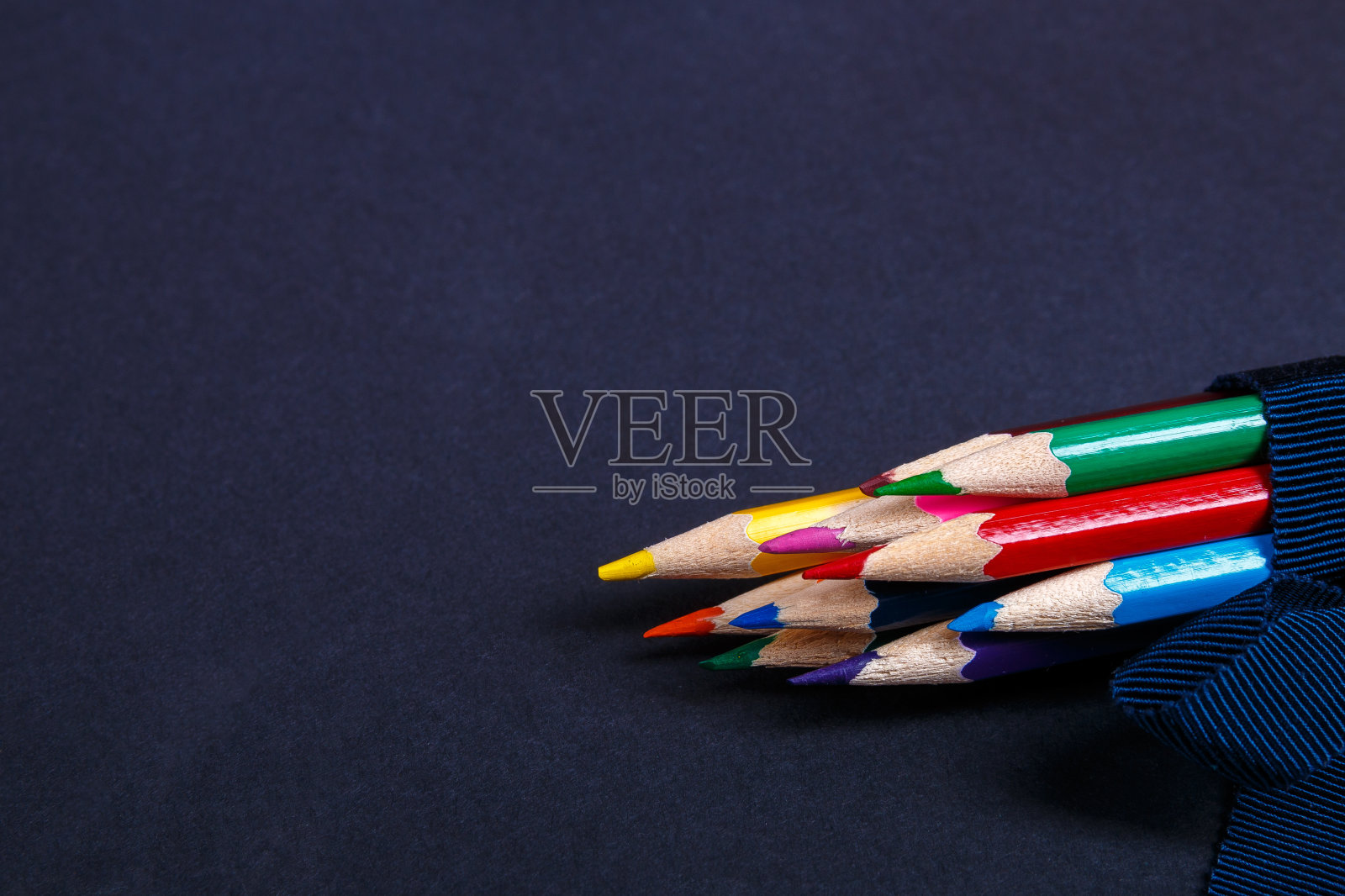 一套用蓝丝带包着的彩色铅笔照片摄影图片