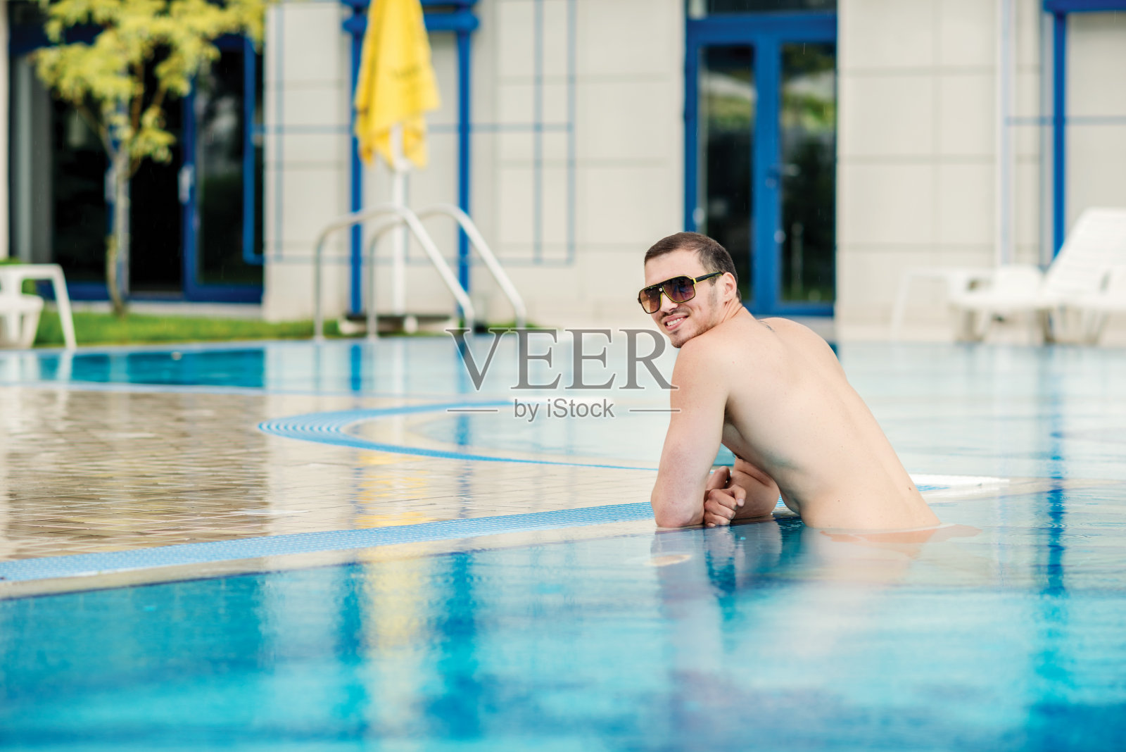 性感的男模特在太阳镜与伟大的身体照片摄影图片