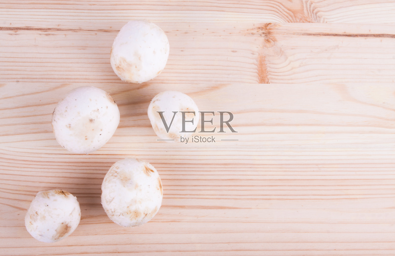 木桌上放着新鲜的蘑菇。照片摄影图片