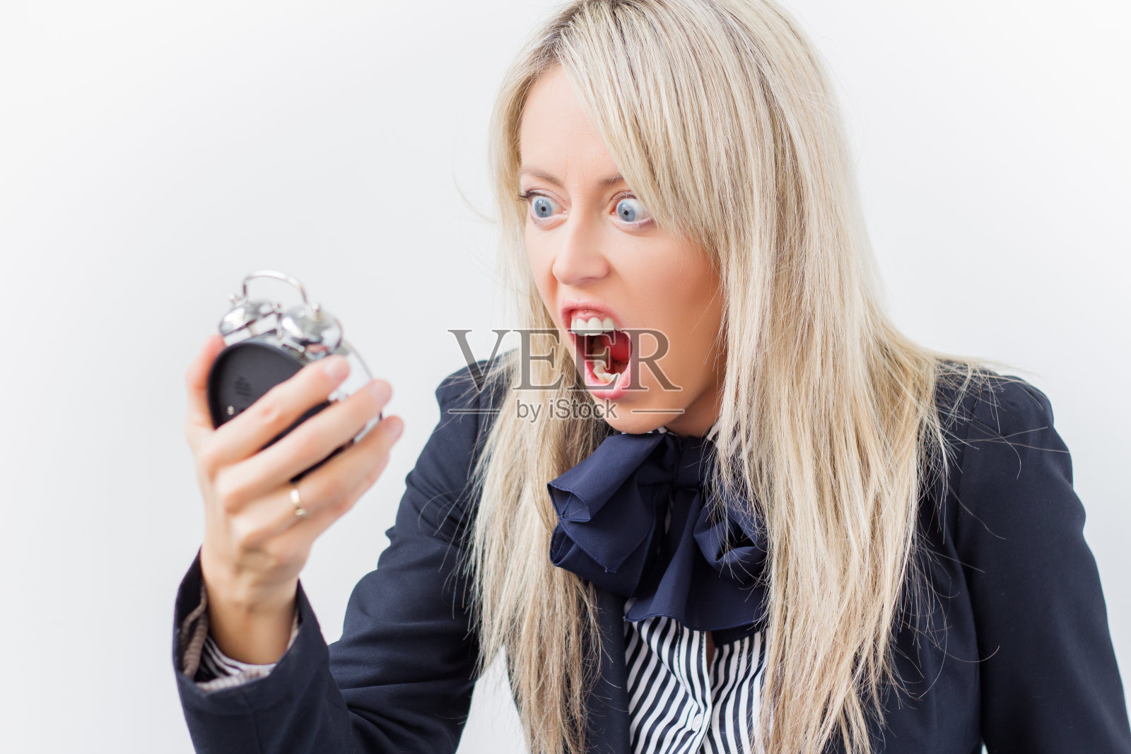 女人对着闹钟大喊大叫照片摄影图片