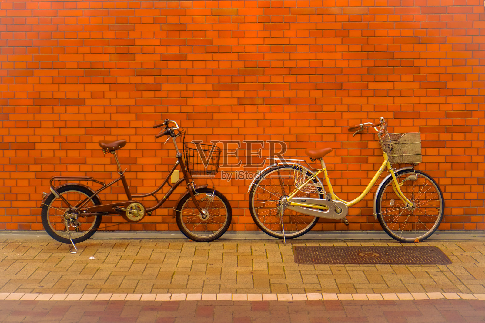 两辆城市自行车和红砖墙。照片摄影图片