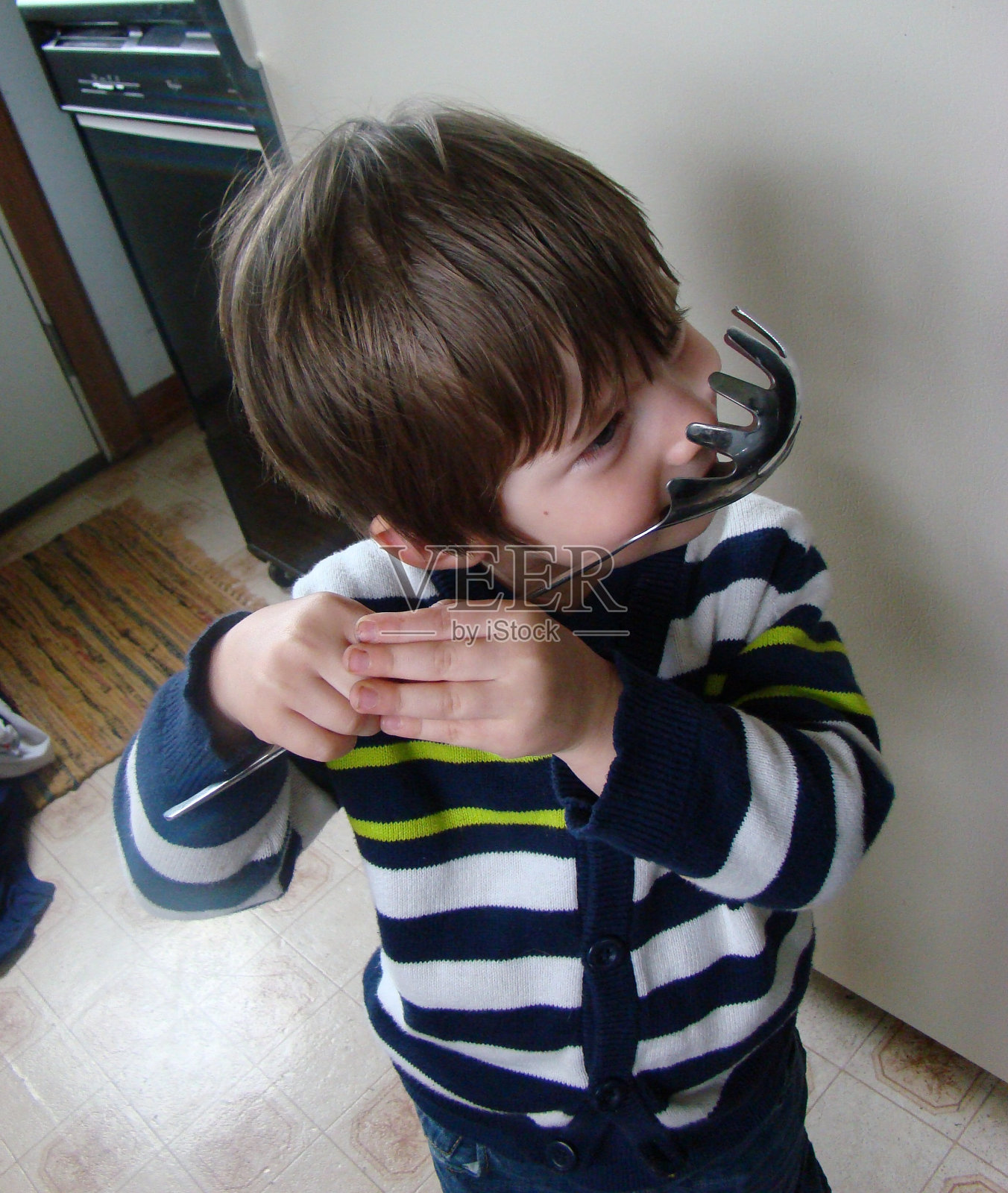 拿着勺子的小男孩照片摄影图片