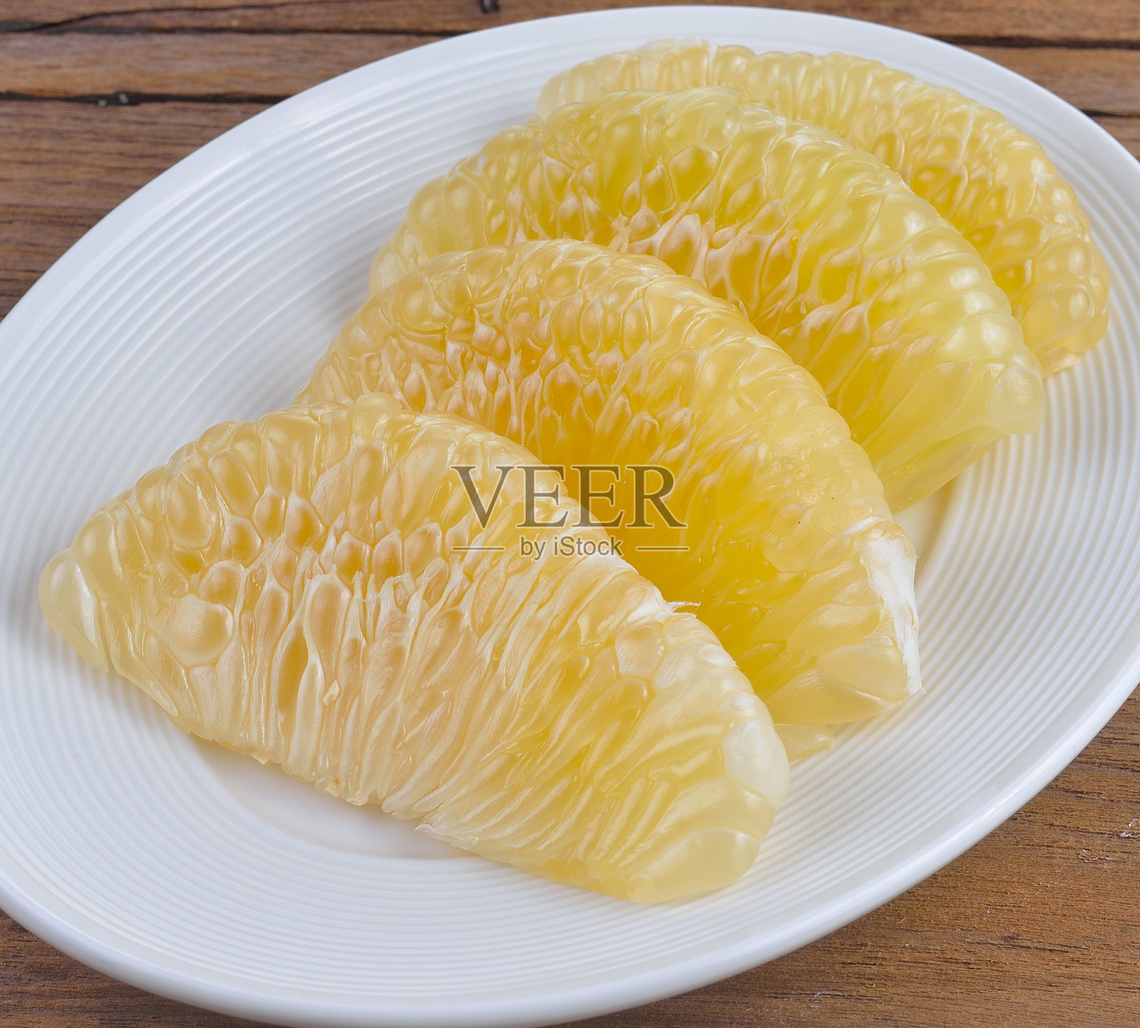 把新鲜的葡萄柚片放在盘子里。照片摄影图片