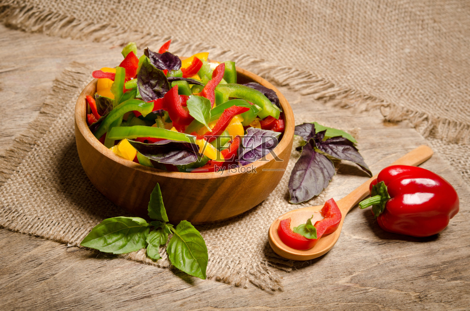 青椒和罗勒放在木碗里做成的沙拉照片摄影图片