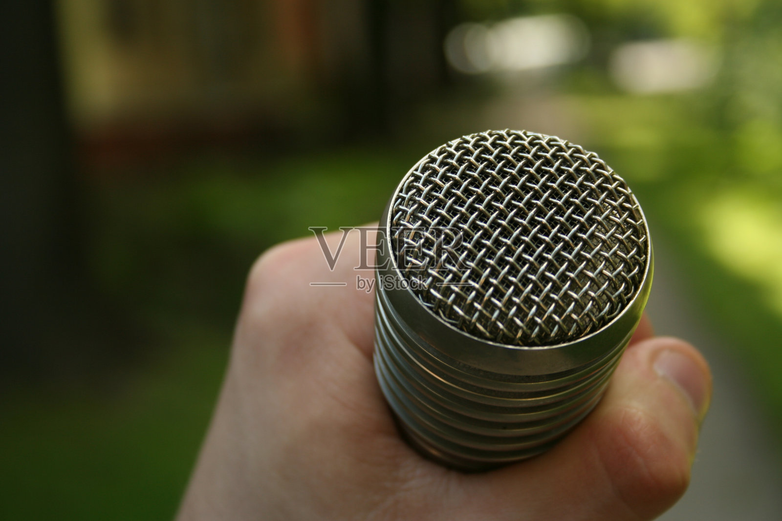 手拿麦克风。在公园采访。照片摄影图片