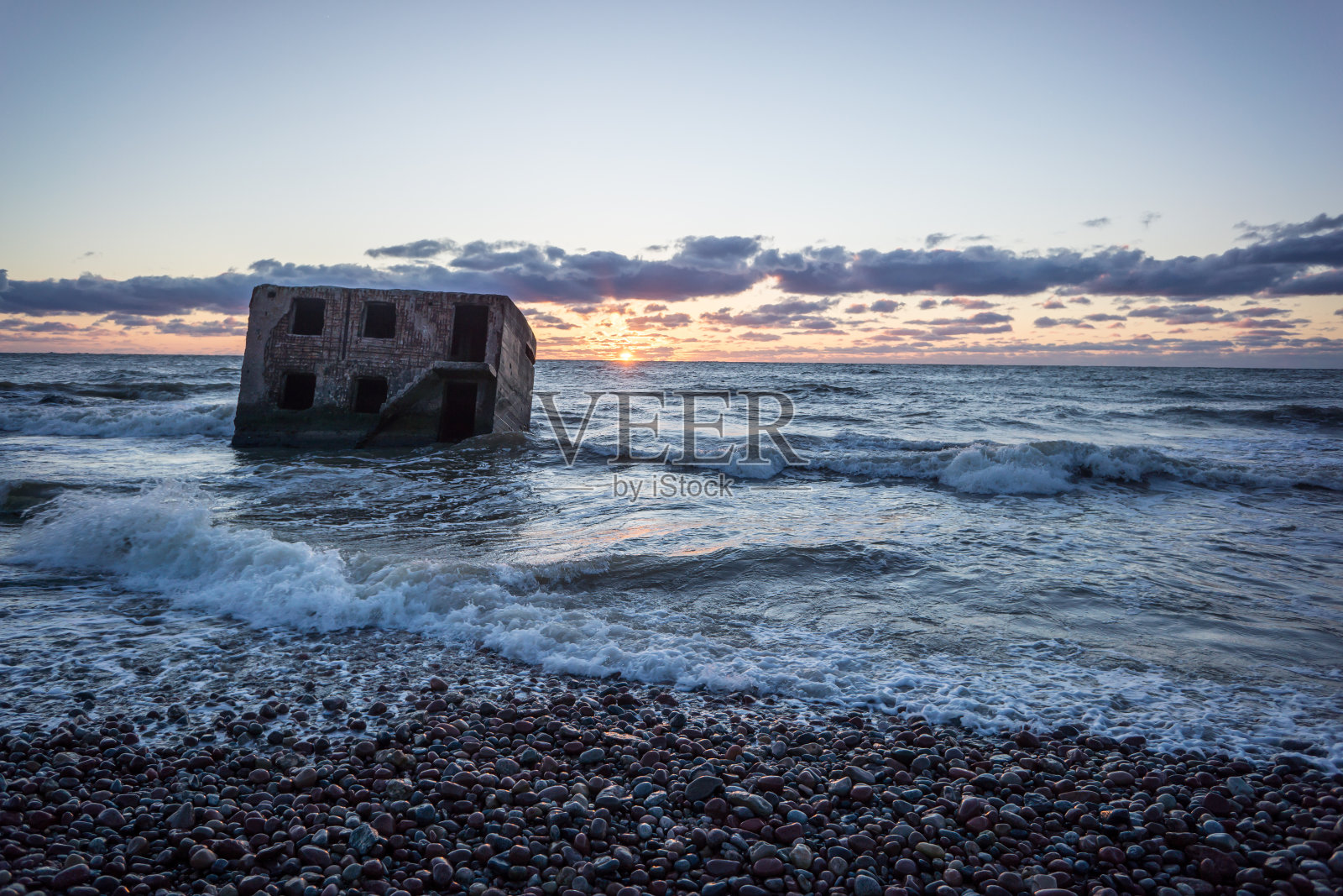 日落时海浪拍打着岩石照片摄影图片