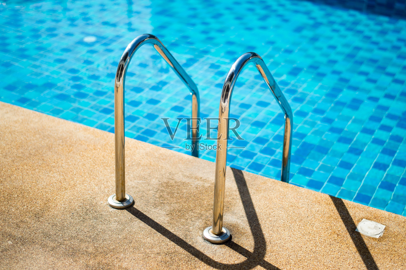 带楼梯的游泳池。照片摄影图片