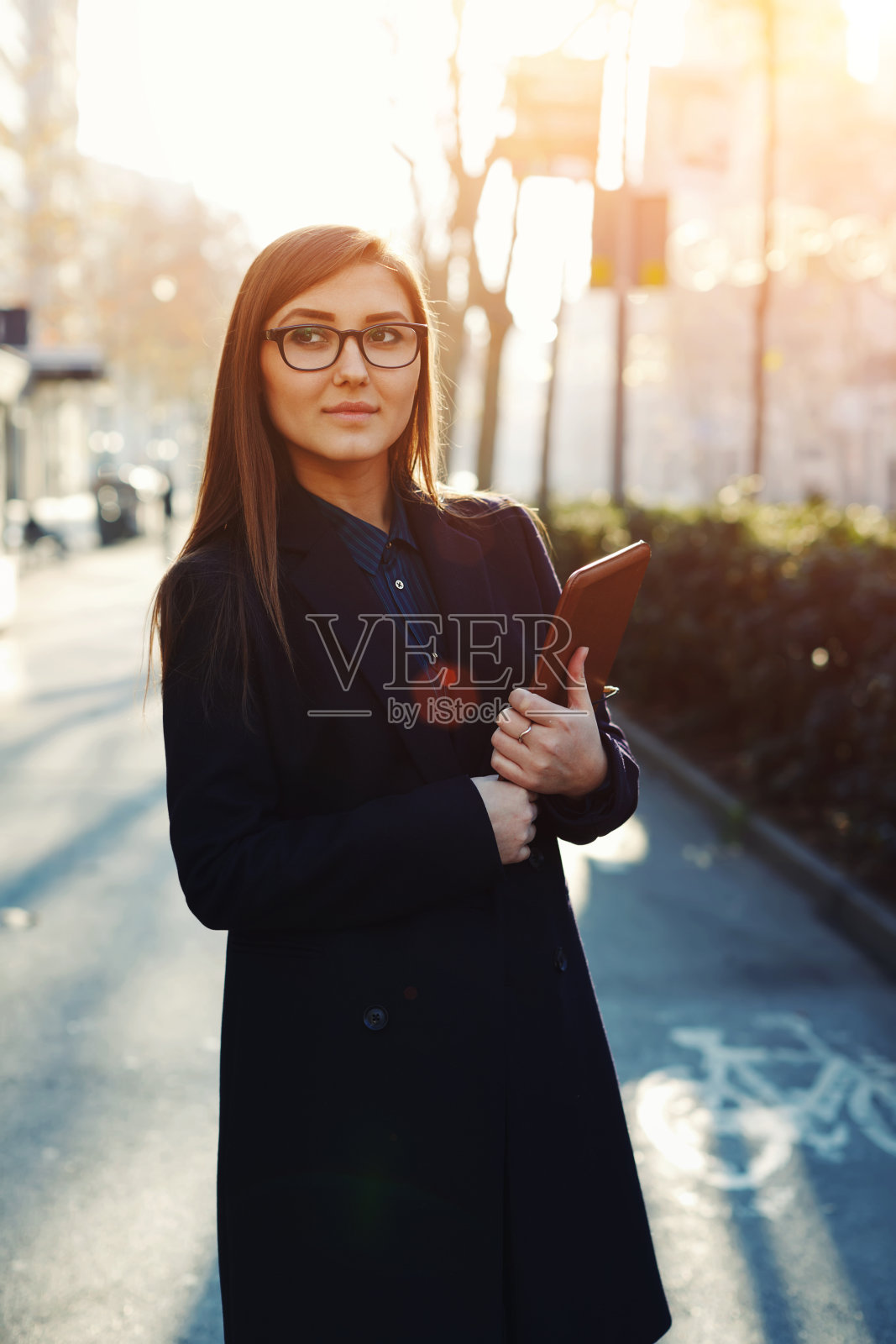 在阳光明媚的日子里，站在街上的女人照片摄影图片
