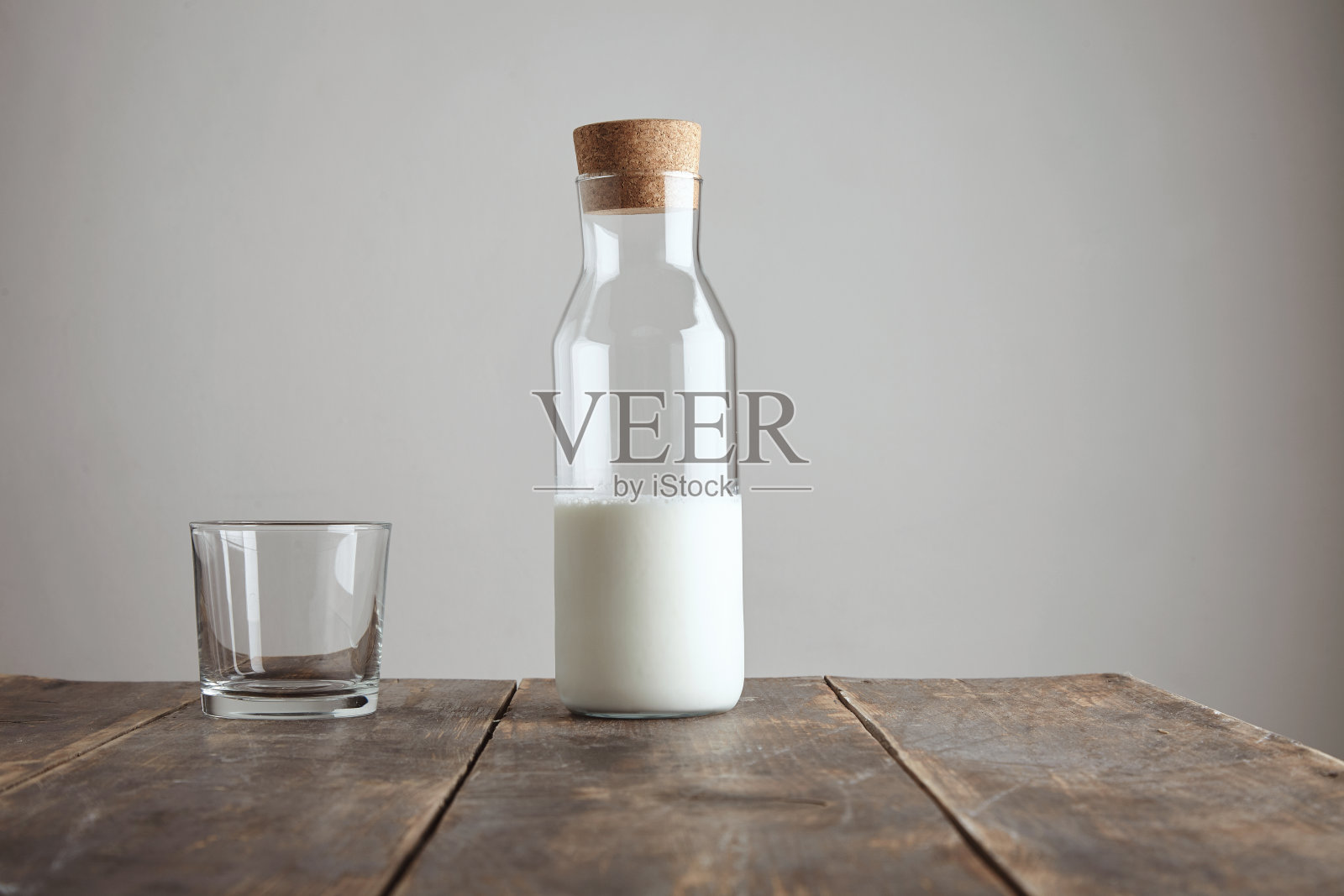 装有牛奶的瓶子被隔离在桌子上照片摄影图片