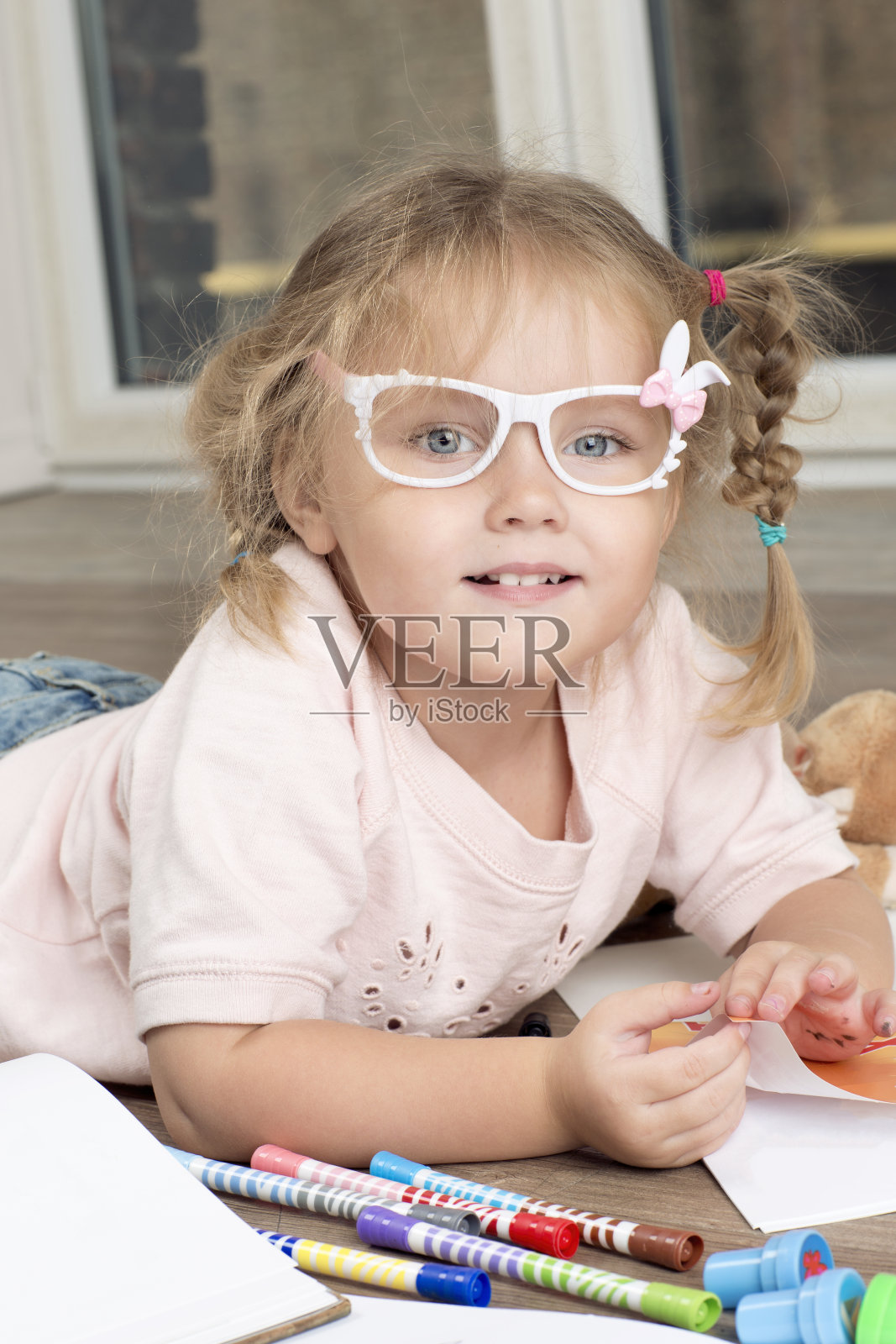 一个戴着眼镜和马克笔的孩子的肖像。照片摄影图片