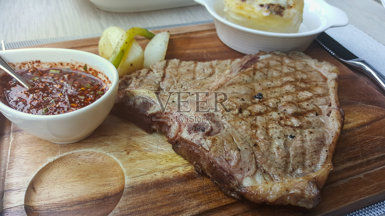 烤丁字骨牛排配上香料调味，以木作背景照片摄影图片