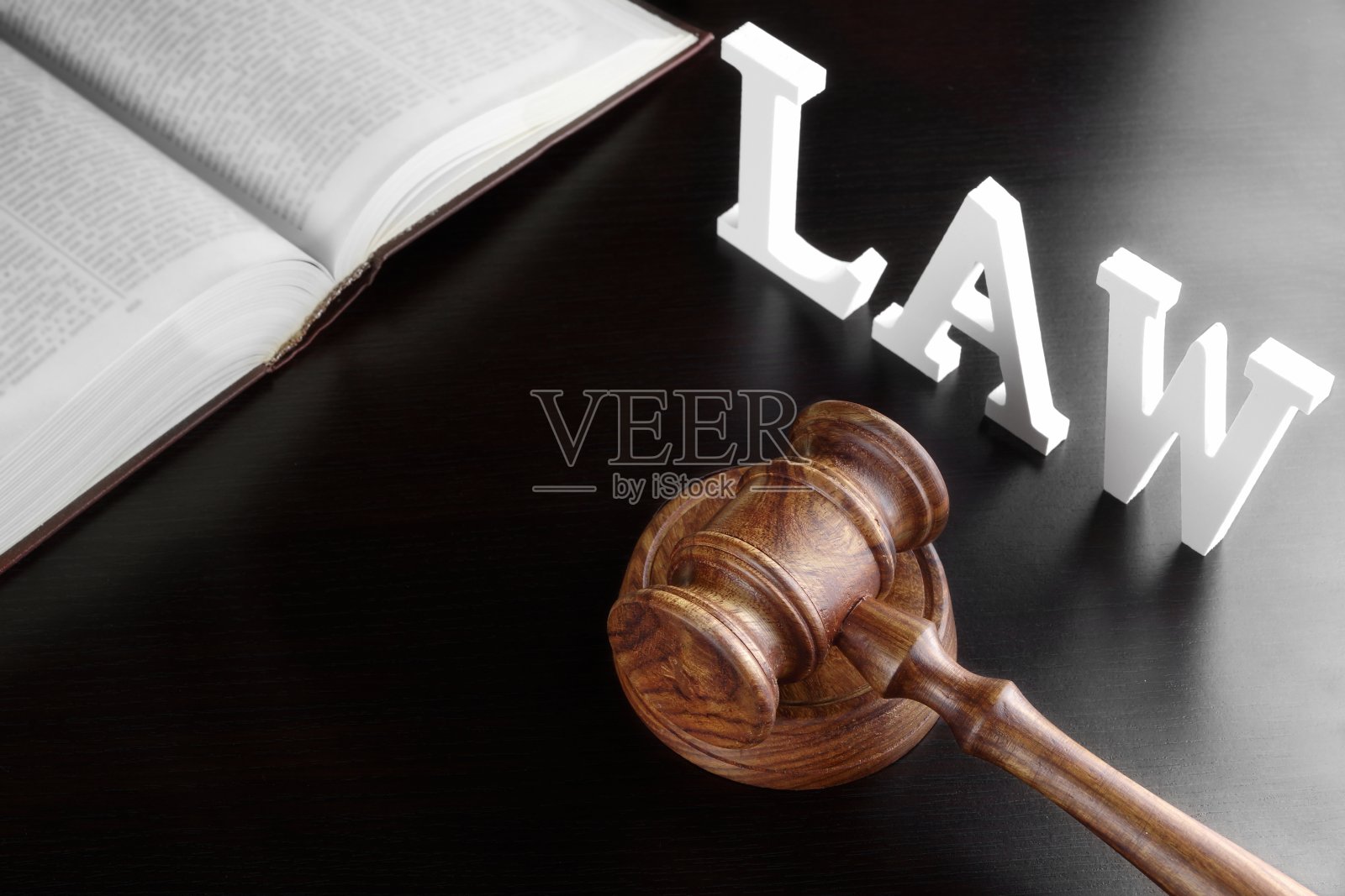 法官 gavel、红色书籍和黑色桌子上的法律标志照片摄影图片