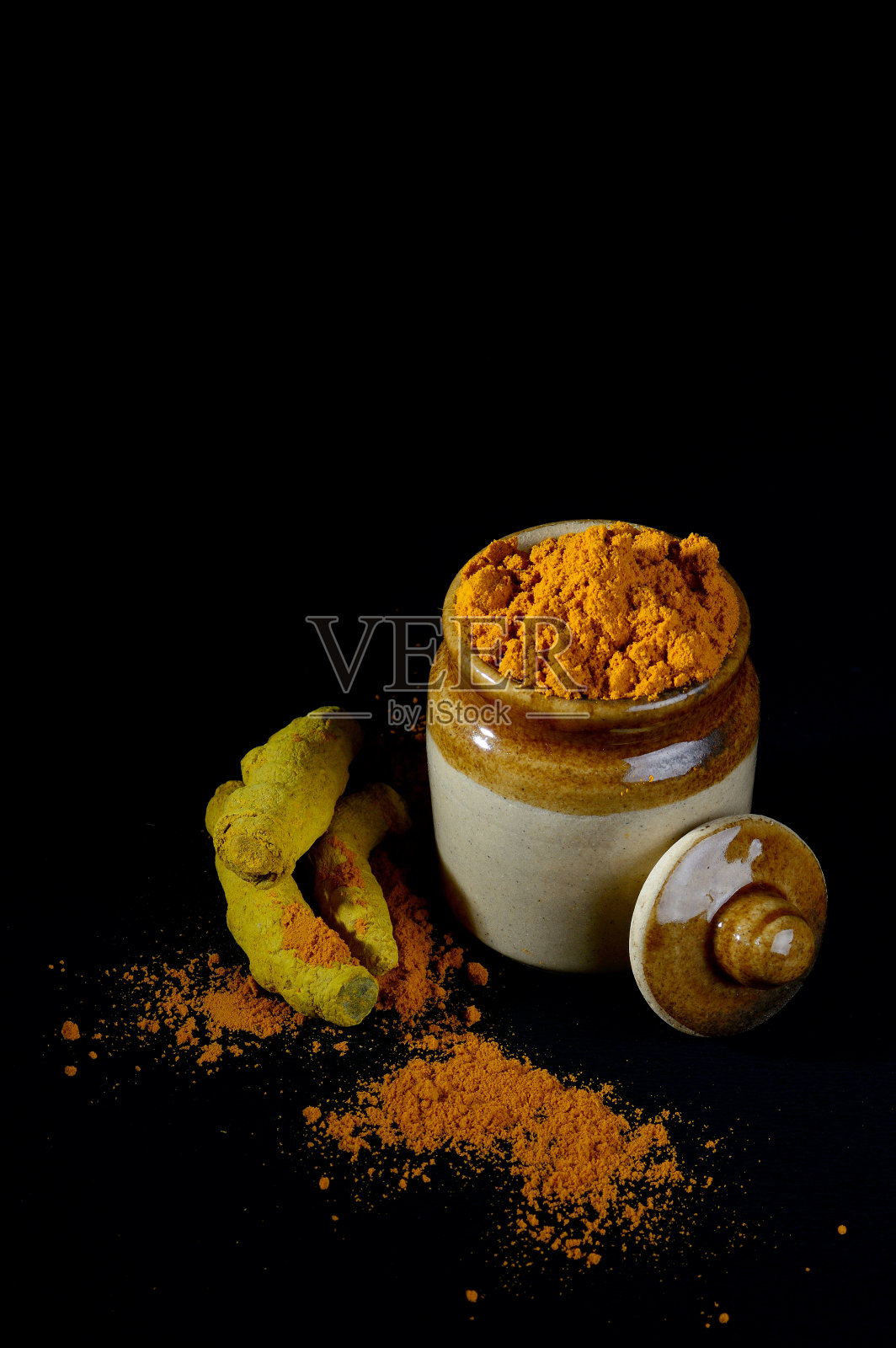 有根或树皮的姜黄粉末，背景为黑色照片摄影图片