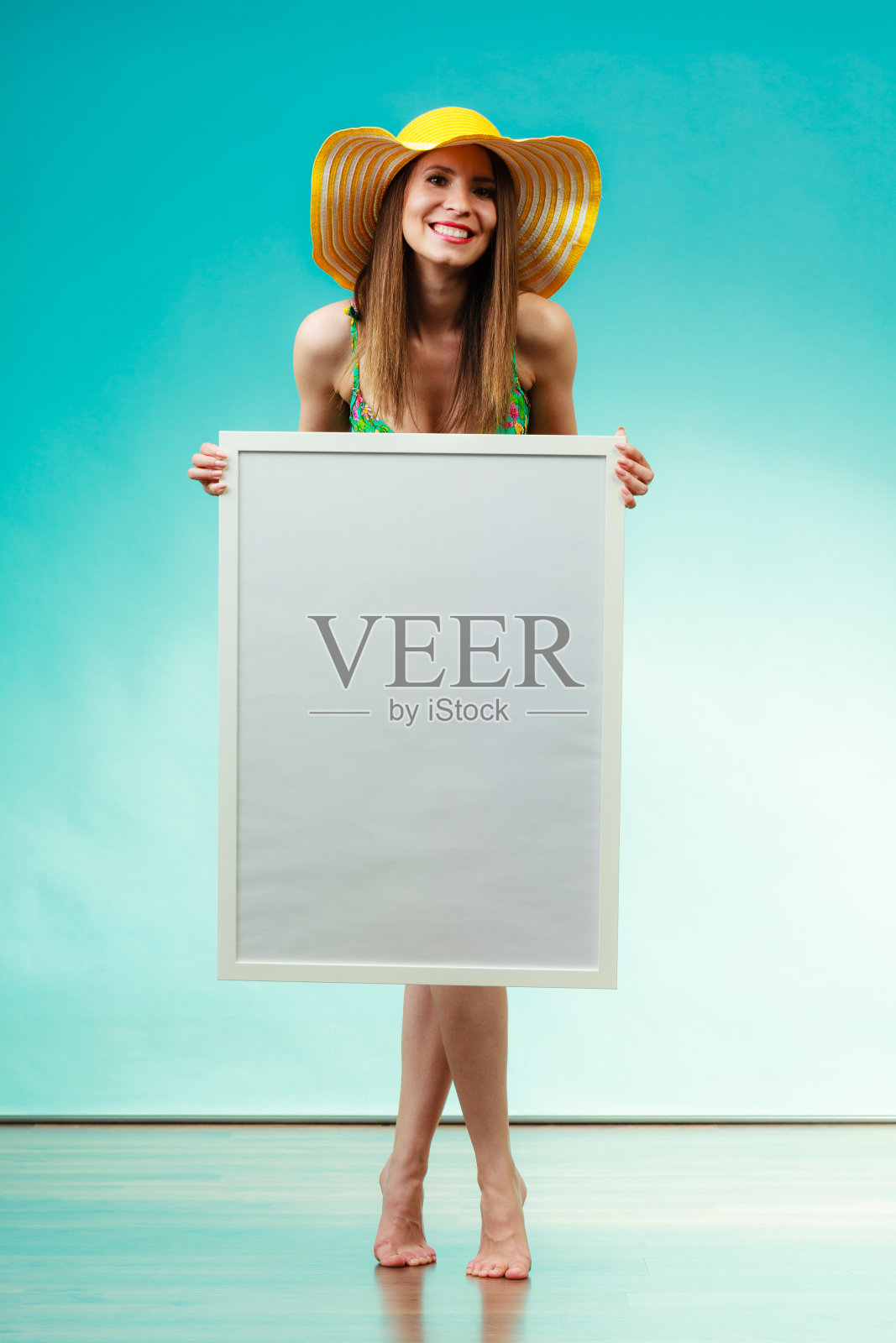 穿着比基尼的女人手持空白展示板。照片摄影图片