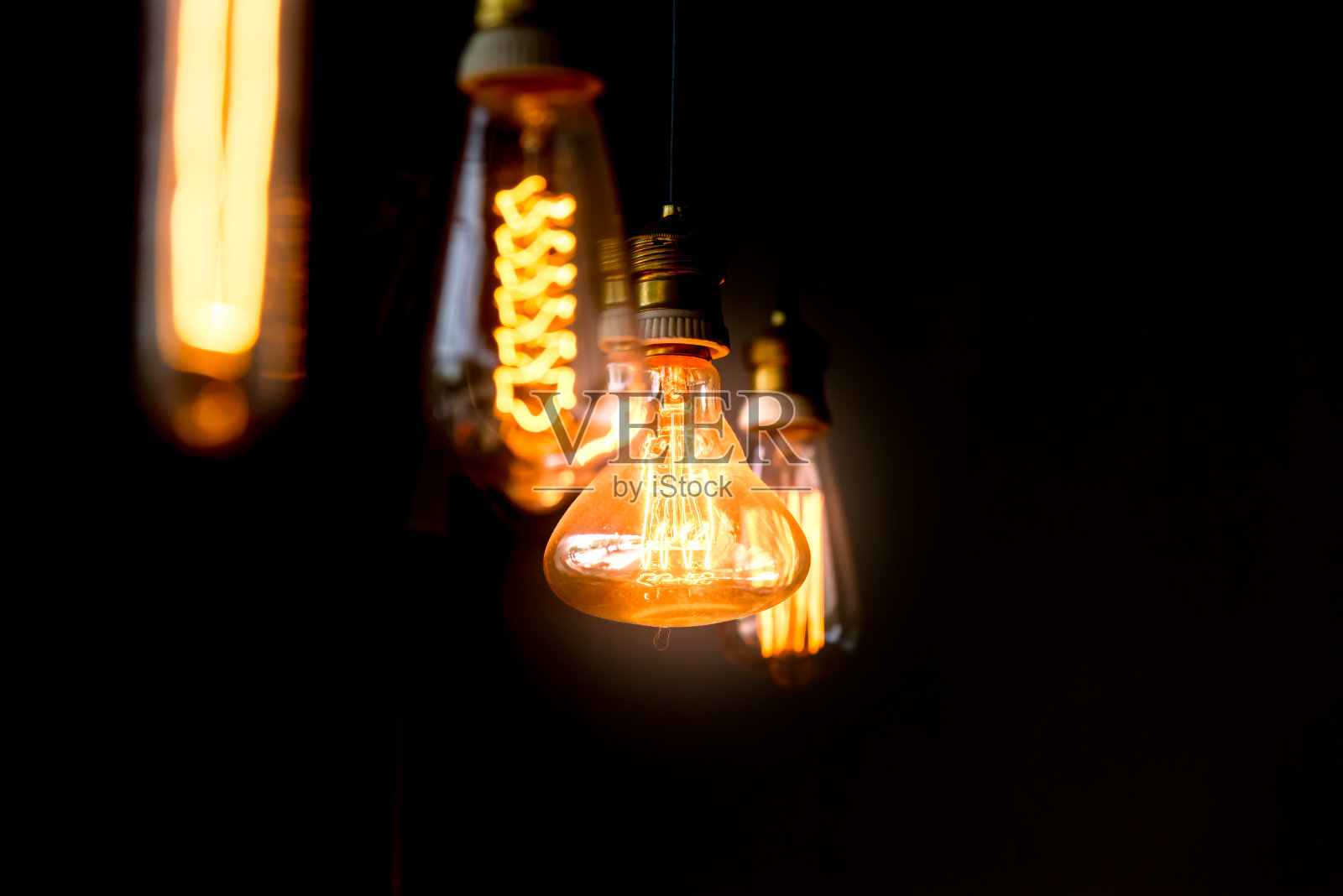 悬挂的橙色装饰灯泡集中在梨形一个照片摄影图片