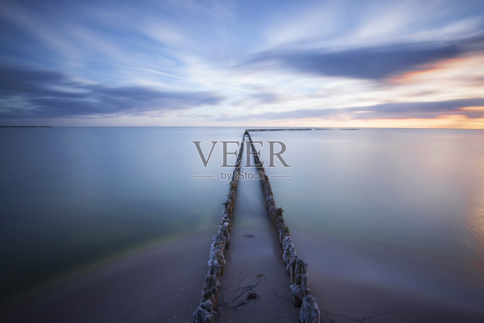 日落时有防波堤的海景照片摄影图片