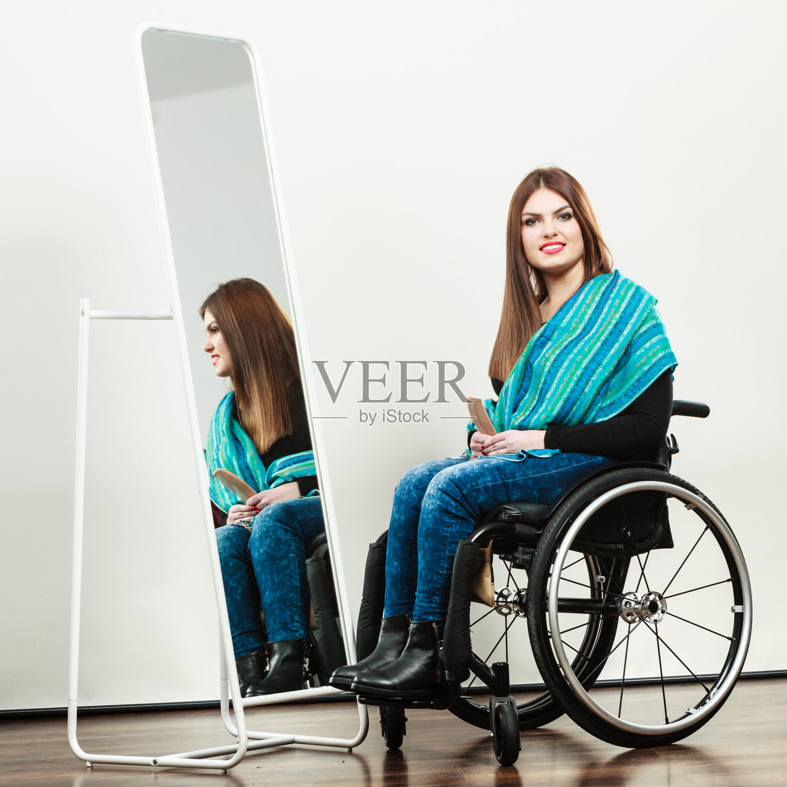 坐在轮椅上梳头发的残疾女孩照片摄影图片