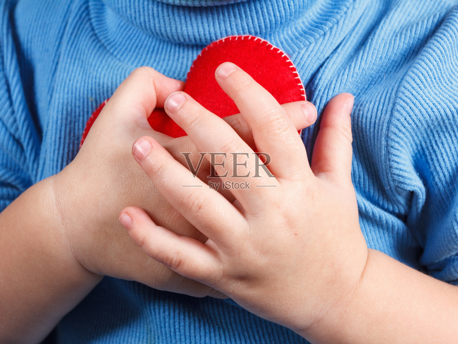 双手抱着宝宝的心象征。爱与关怀的概念照片摄影图片