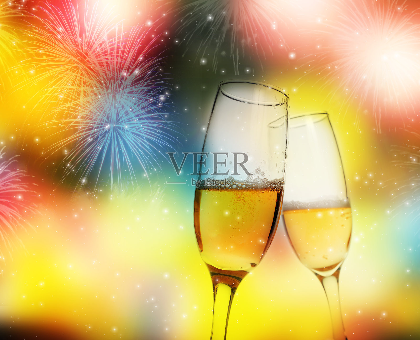 在烟花的映衬下，用香槟杯敬酒庆祝新年照片摄影图片