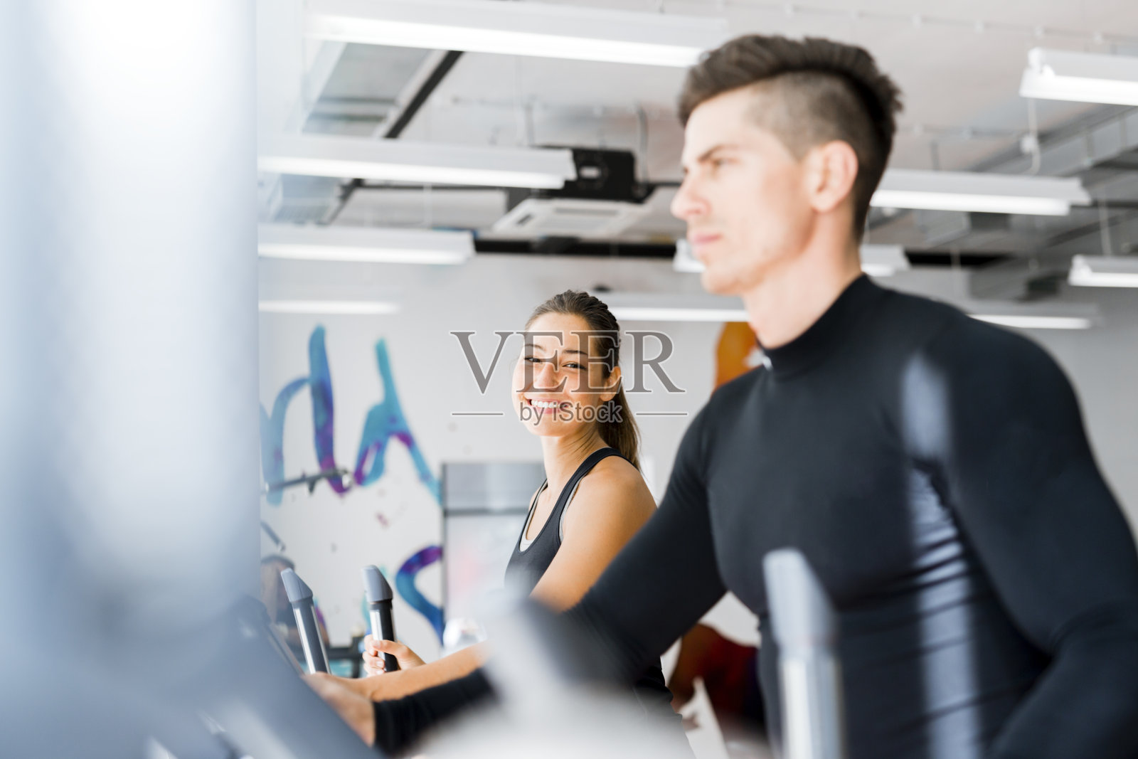 一群年轻的人在椭圆教练机上锻炼照片摄影图片