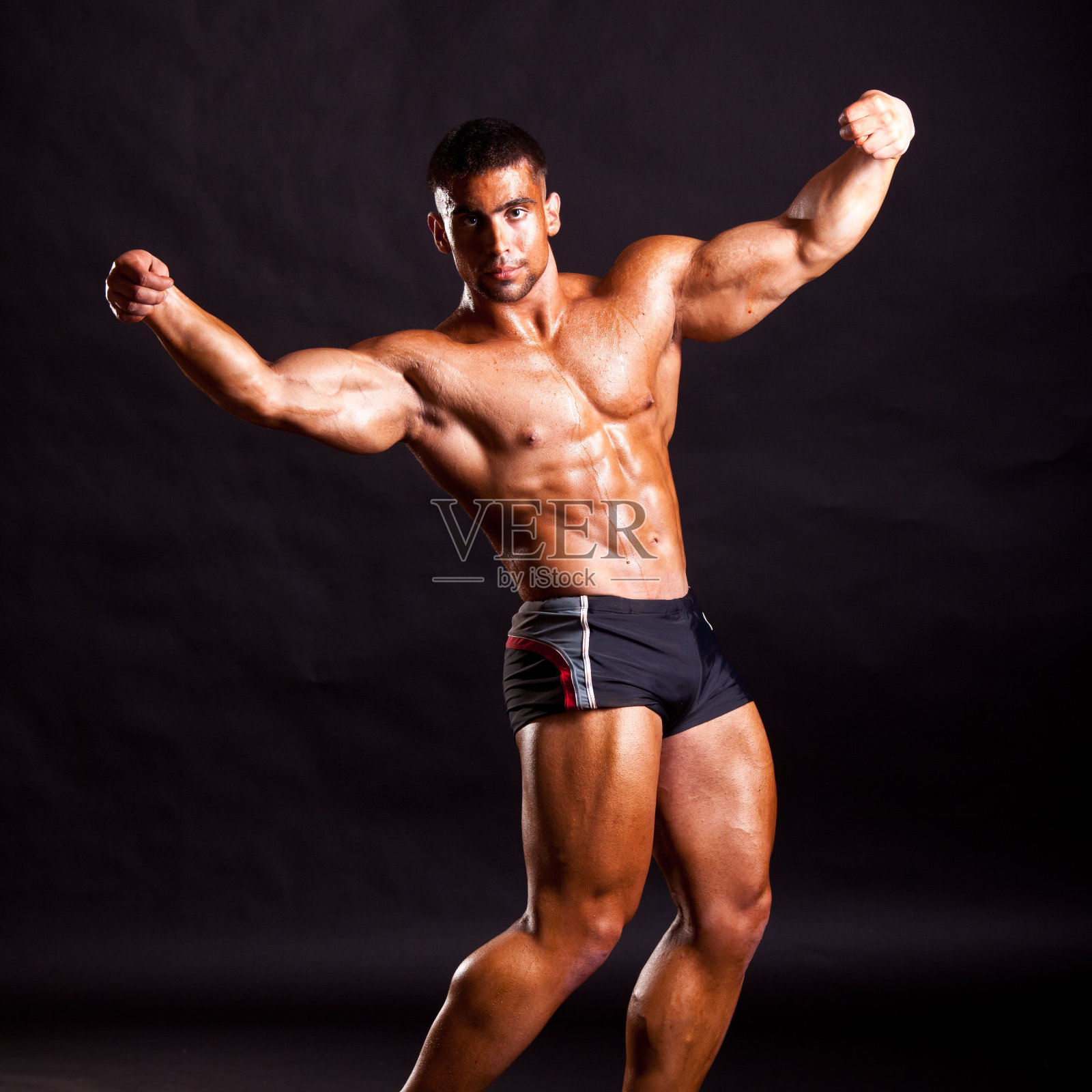 年轻健美运动员摆姿势照片摄影图片