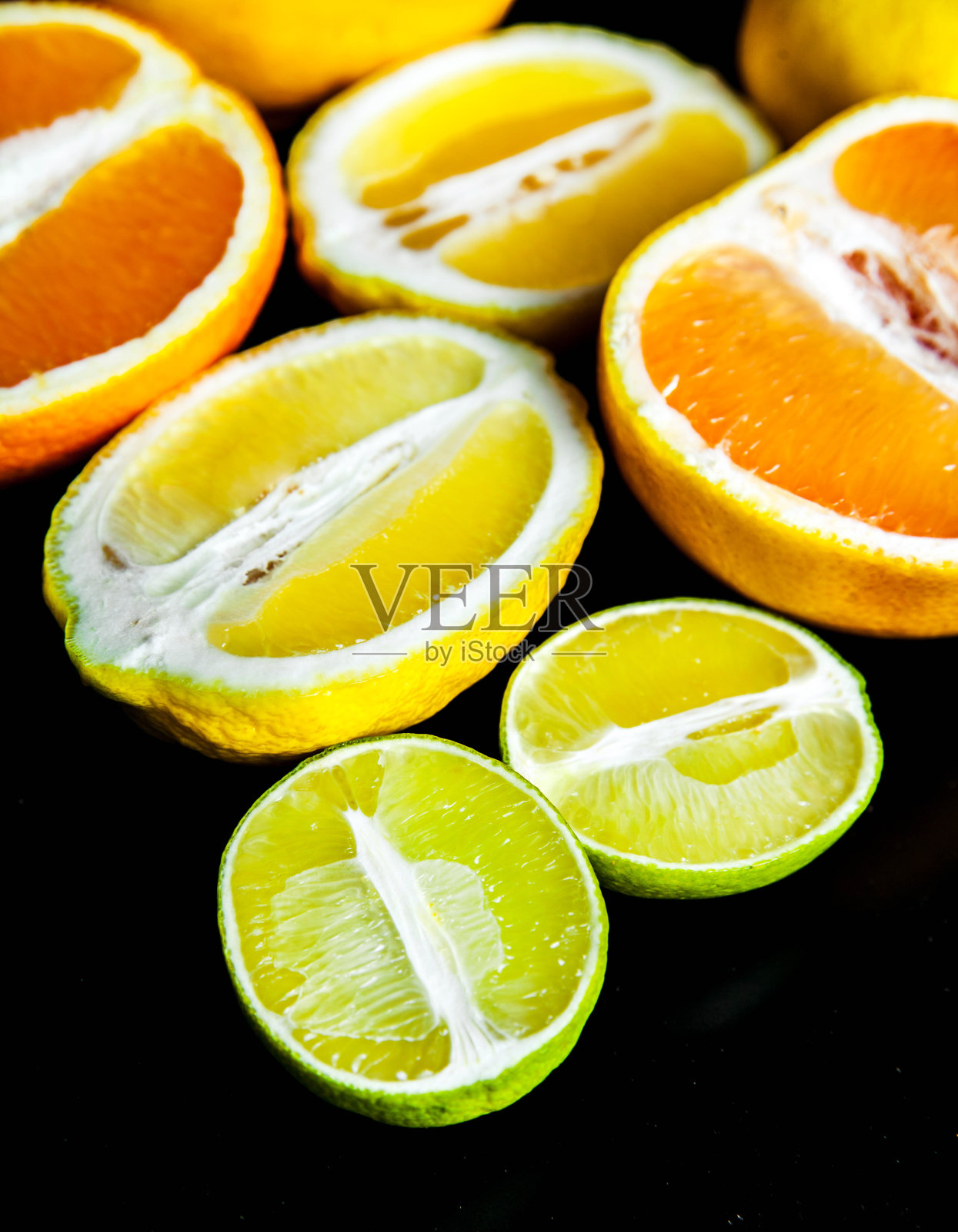在黑色背景上切片的柑橘类水果。食物照片摄影图片