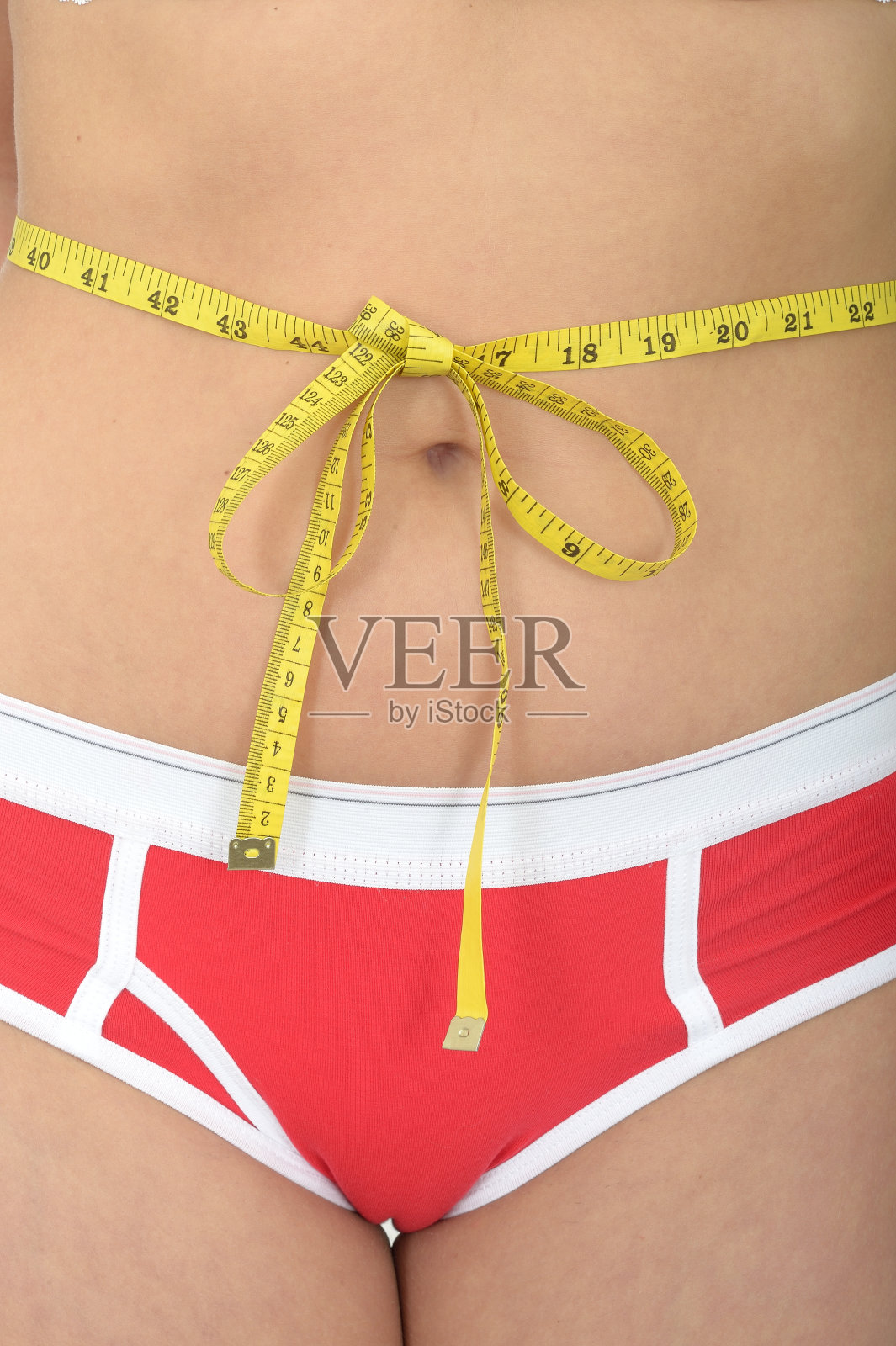 腰间系着卷尺的年轻女子照片摄影图片