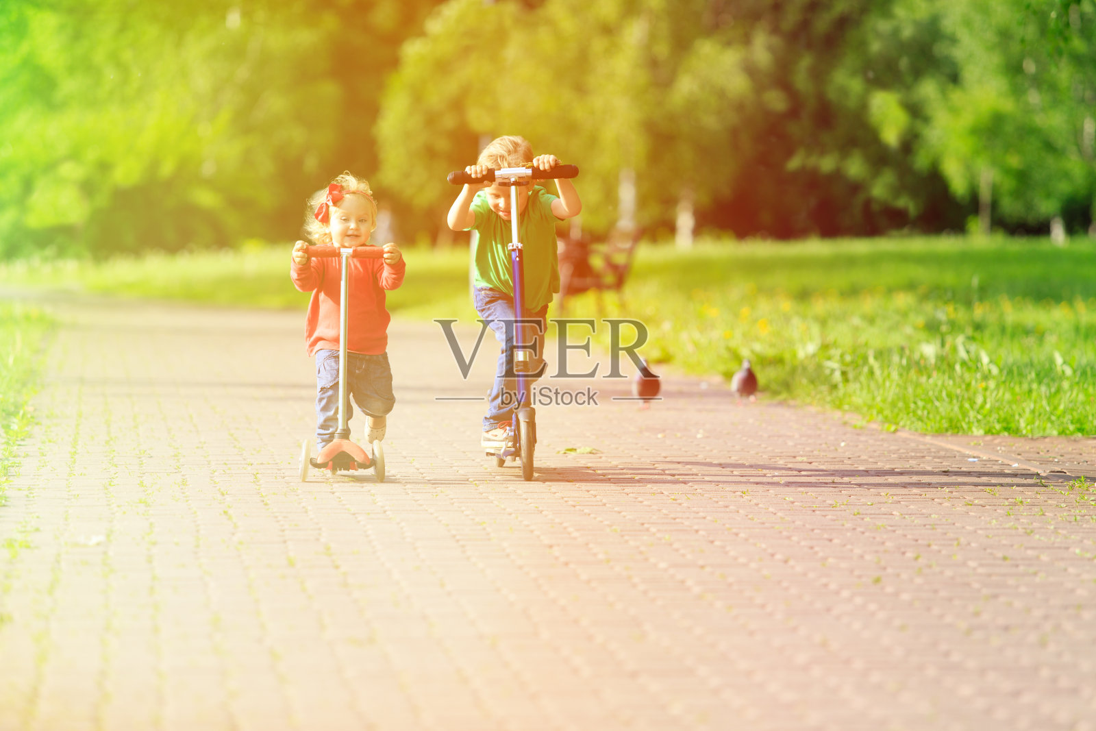 孩子们在夏天的公园里骑摩托车照片摄影图片