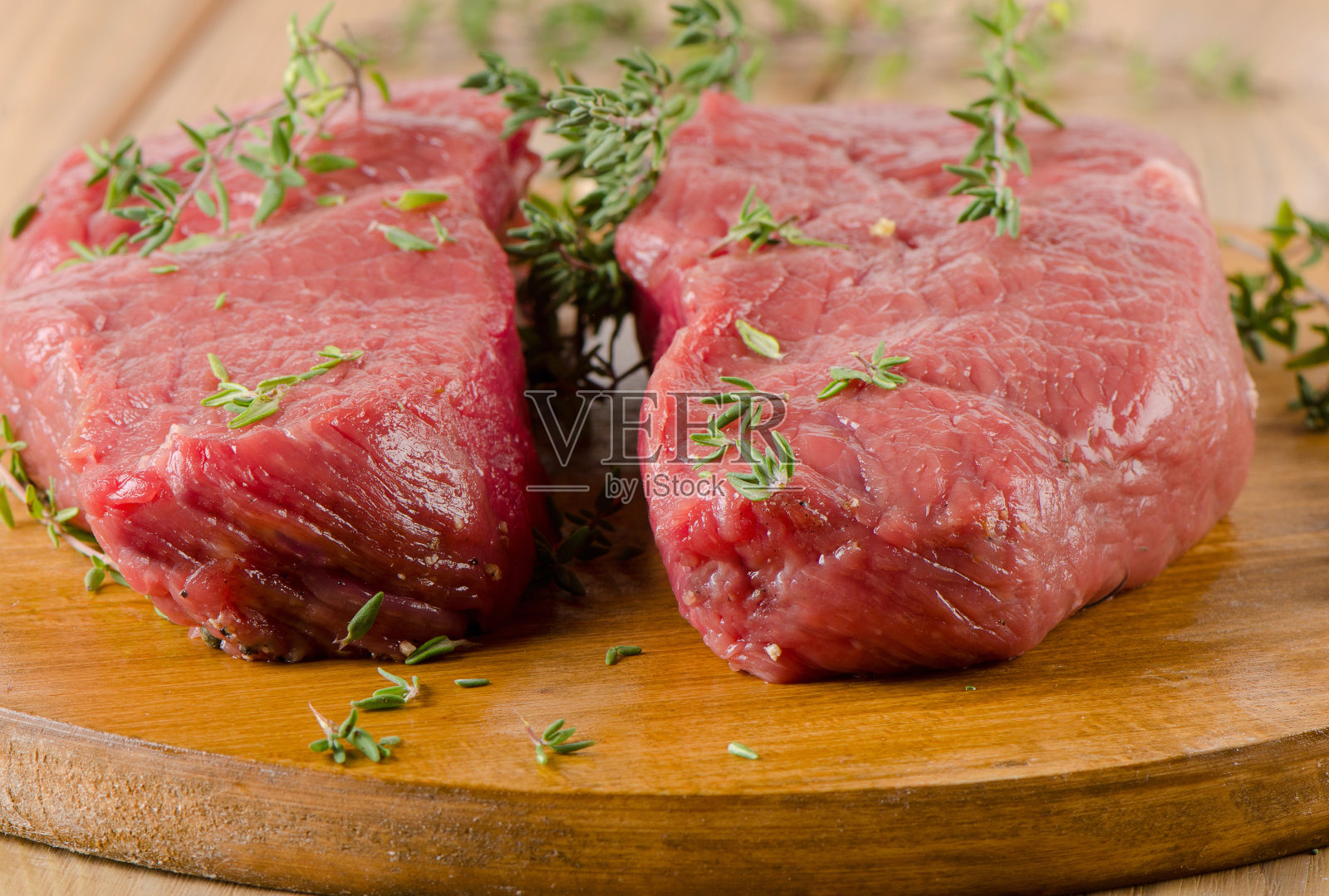 木桌上的生牛排。照片摄影图片