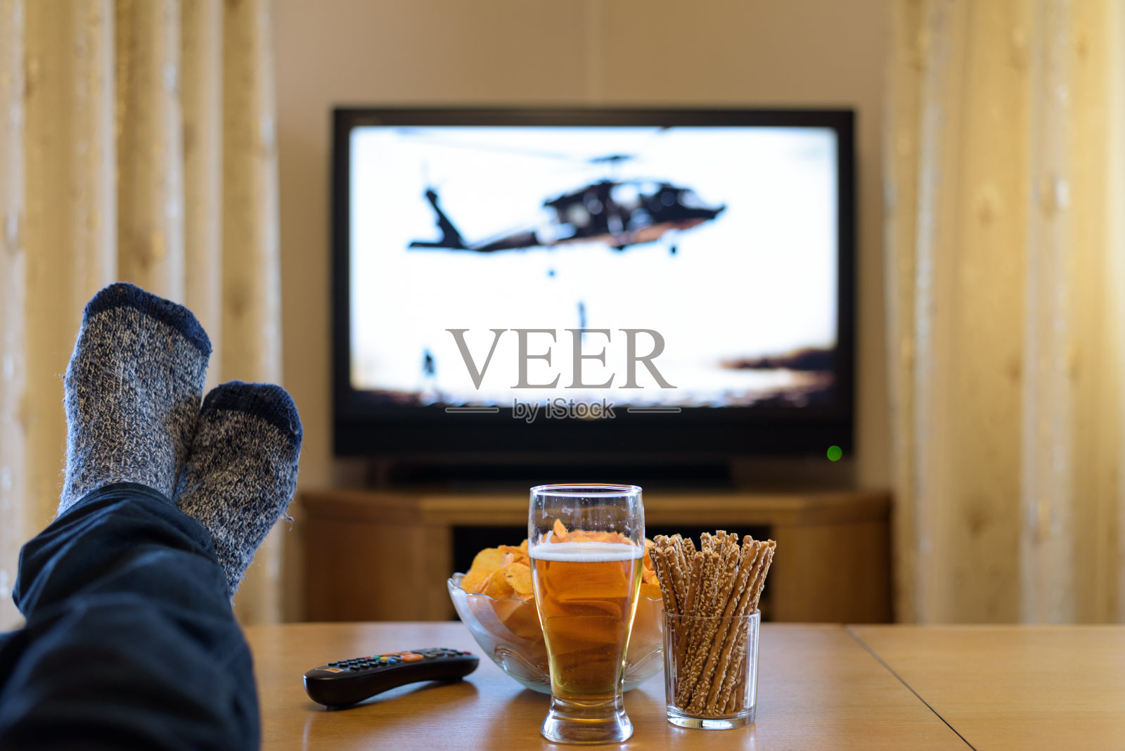 一个人脚搁在桌上看战争电影照片摄影图片