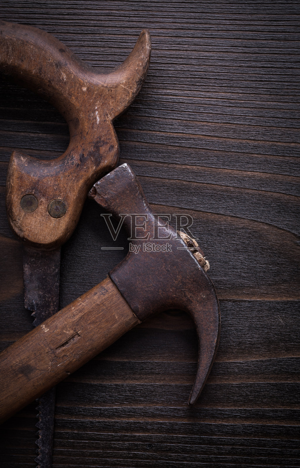 一套生锈的手锯和羊角锤在木板上照片摄影图片
