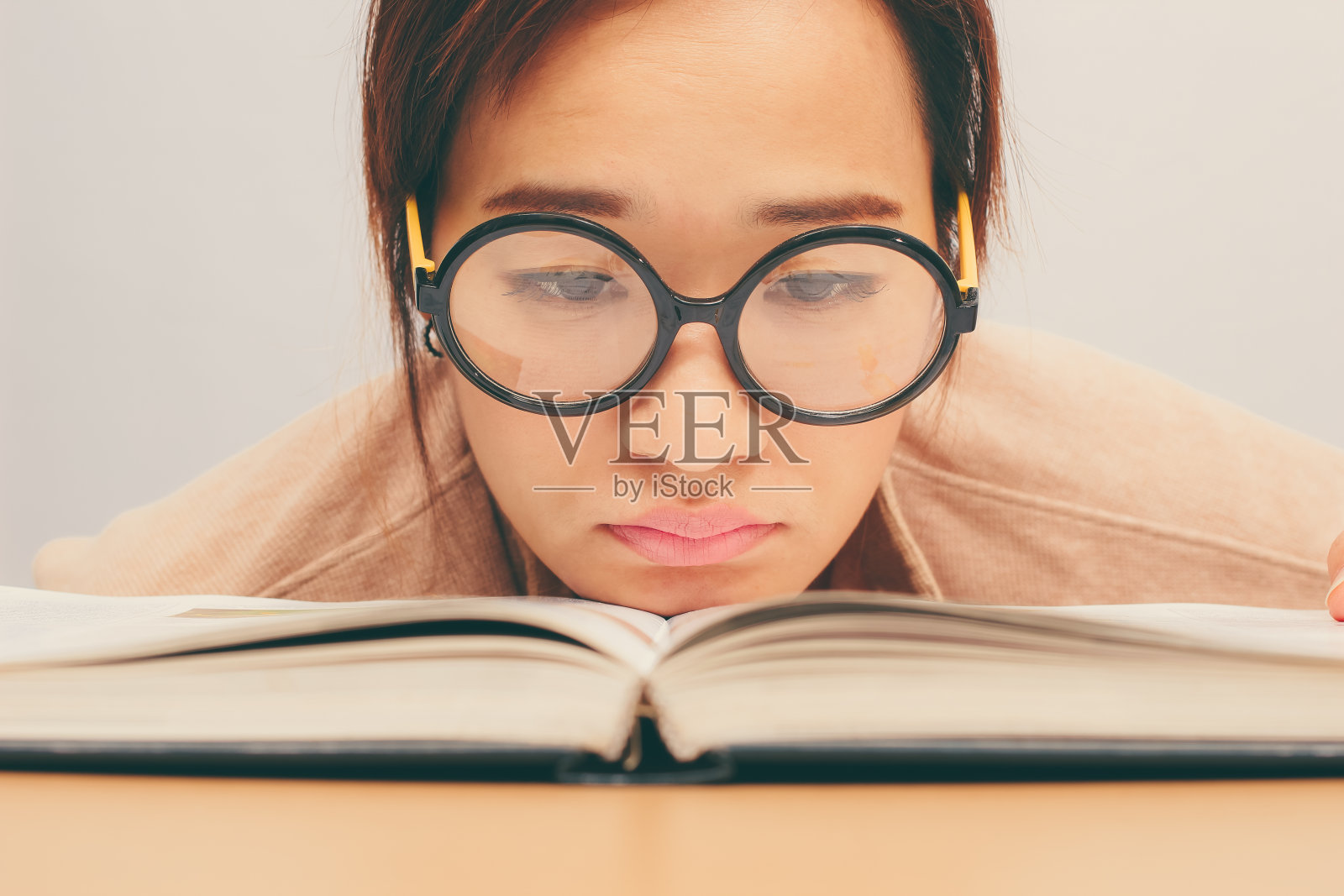 书呆子年轻的亚洲女学生厌倦了读书照片摄影图片