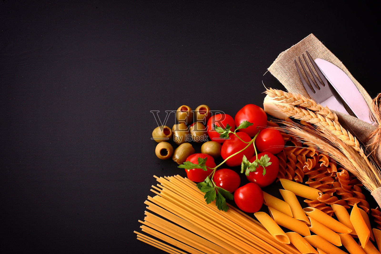 季节性的黑色餐桌与意大利面和餐具照片摄影图片