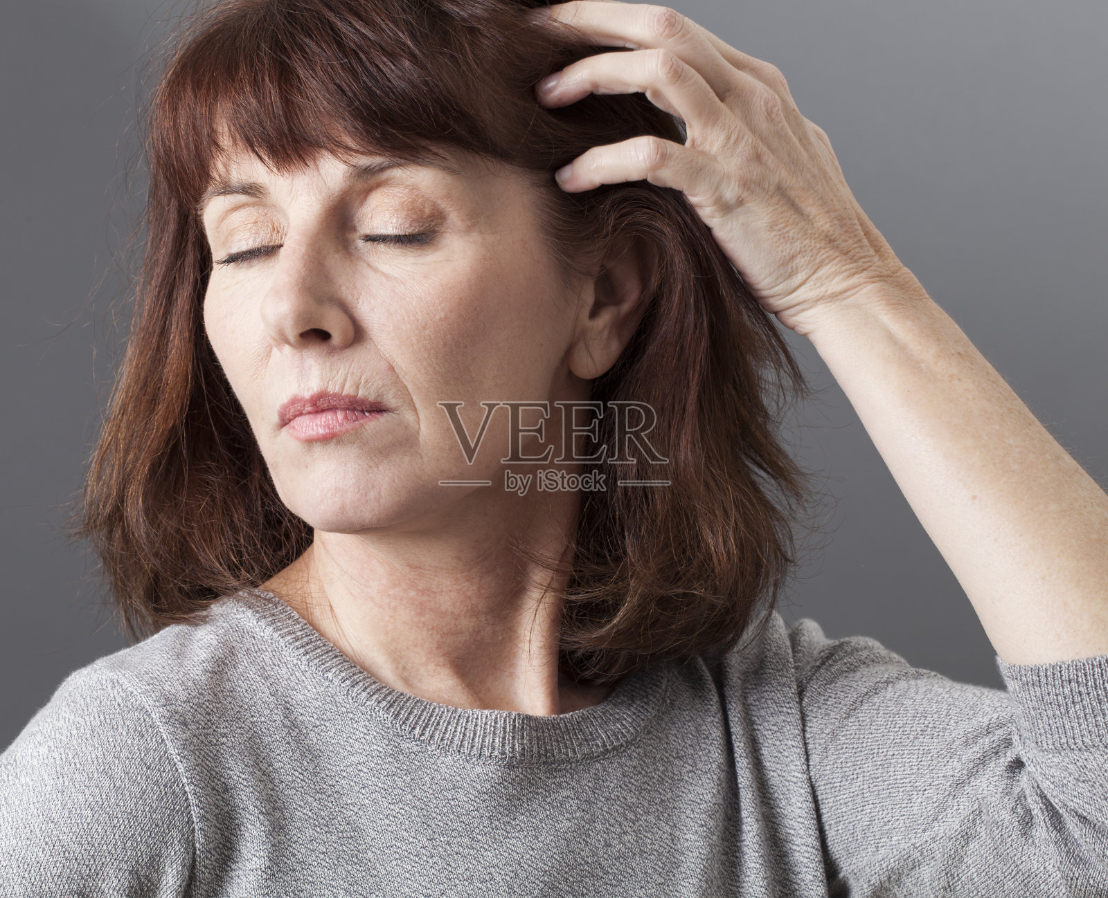 思考50年代的女性关心她的皮肤和头发质量照片摄影图片