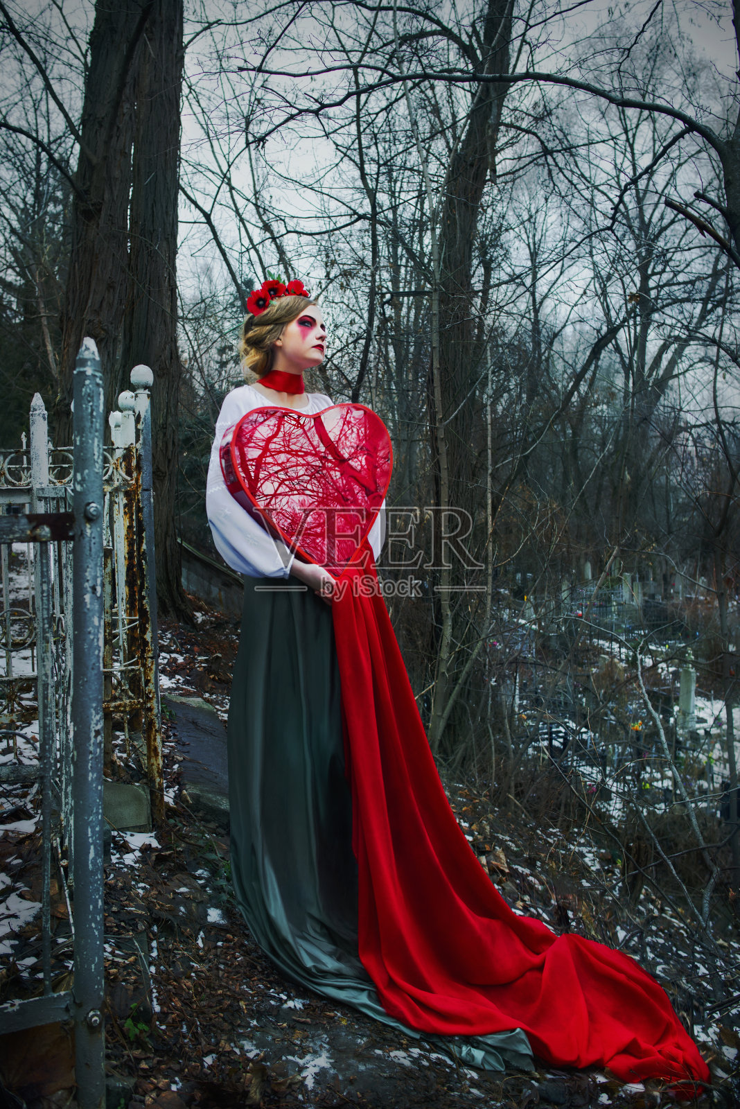 年轻的金发女孩在墓地里哭着流着血照片摄影图片