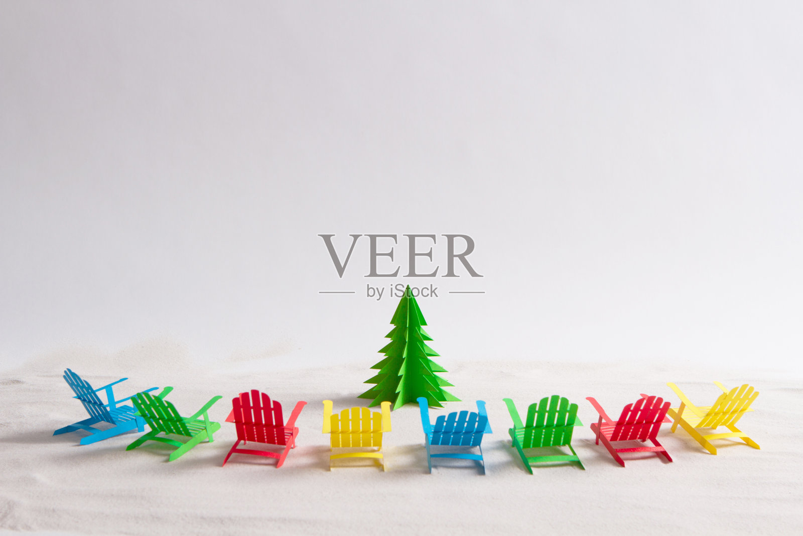 明亮的阳光懒洋洋地躺在纸做的圣诞树周围。照片摄影图片