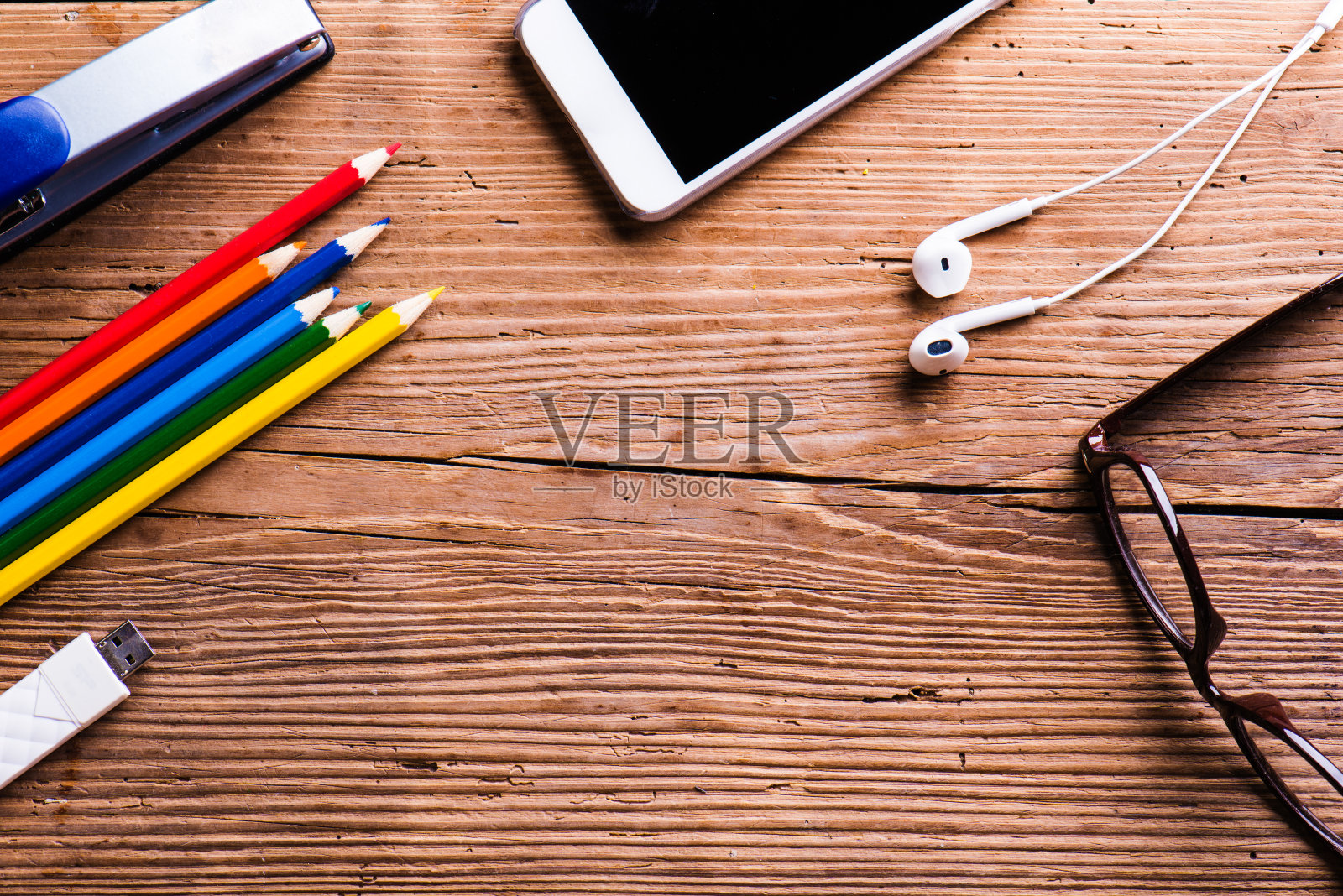 智能手机、耳机、眼镜和办公桌面上的其他物品照片摄影图片