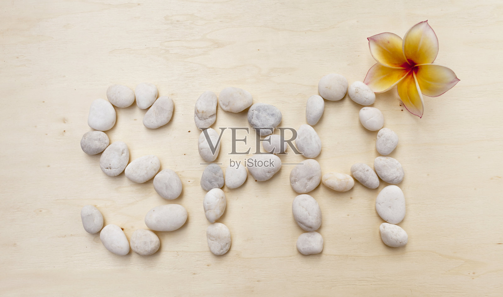 温泉石文字上的木材背景与花照片摄影图片