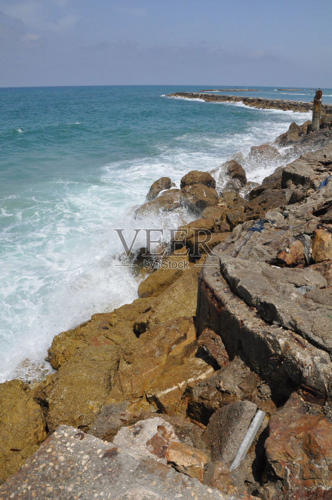 绿色的地中海海浪拍打着岩石照片摄影图片