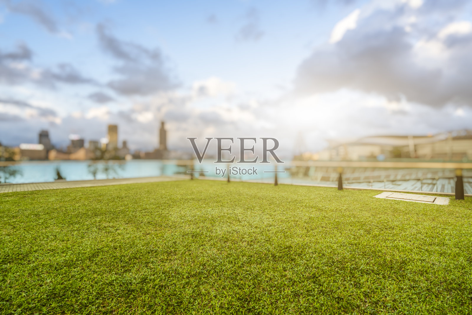 白天以现代建筑为背景的绿色草坪照片摄影图片