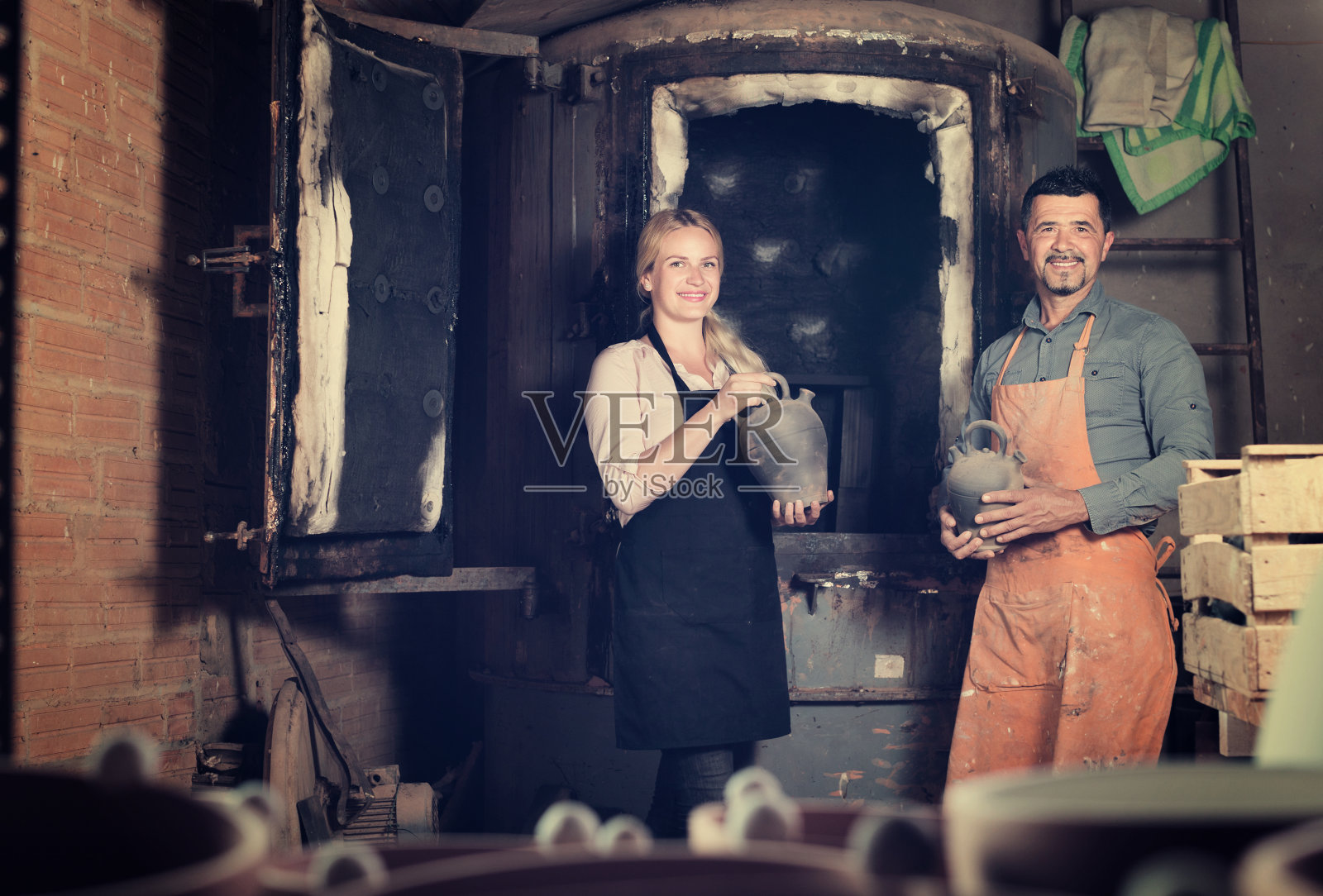 拿着黑色陶瓷花瓶的陶工照片摄影图片