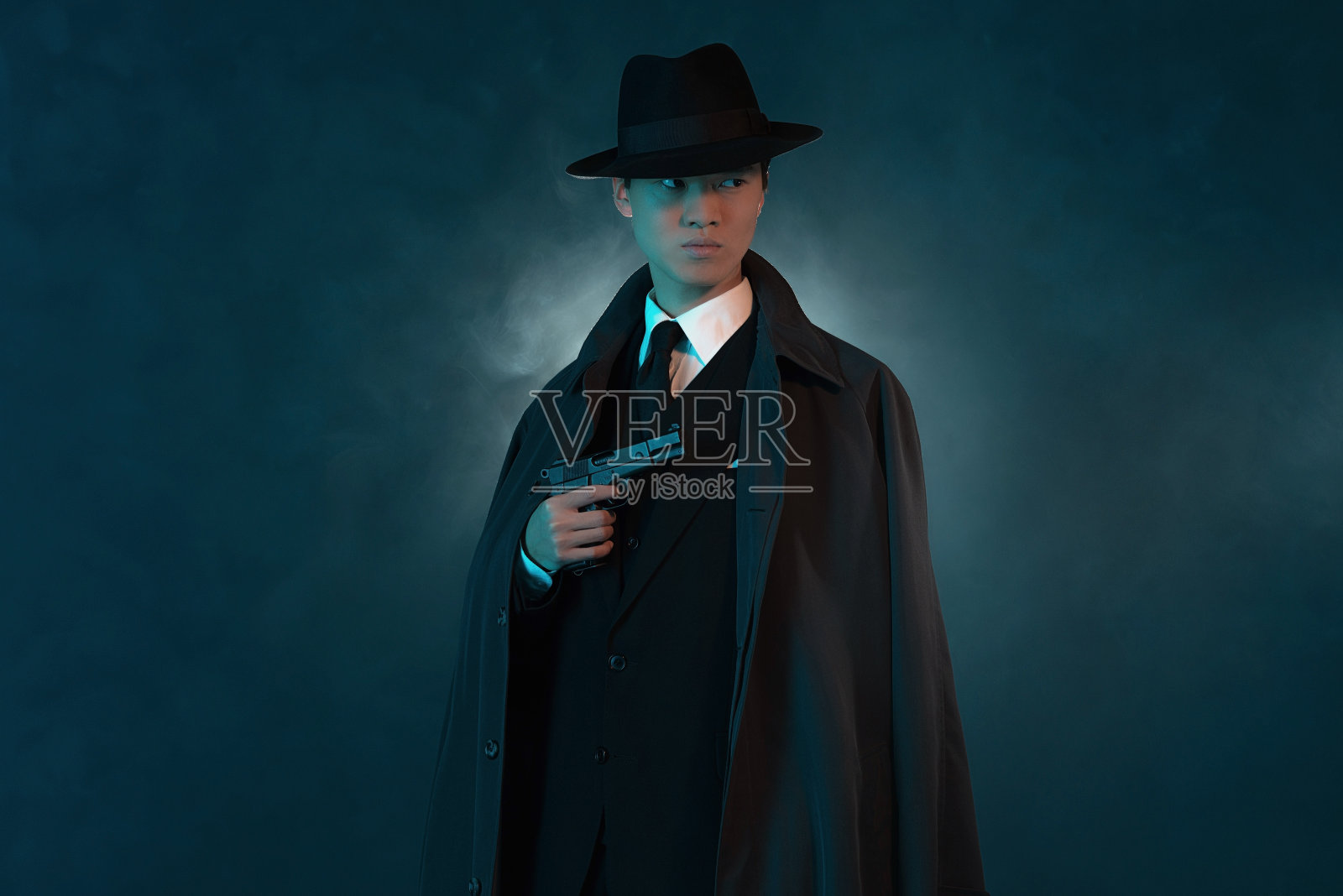 危险复古1940年亚洲黑帮时尚长大衣的人。照片摄影图片