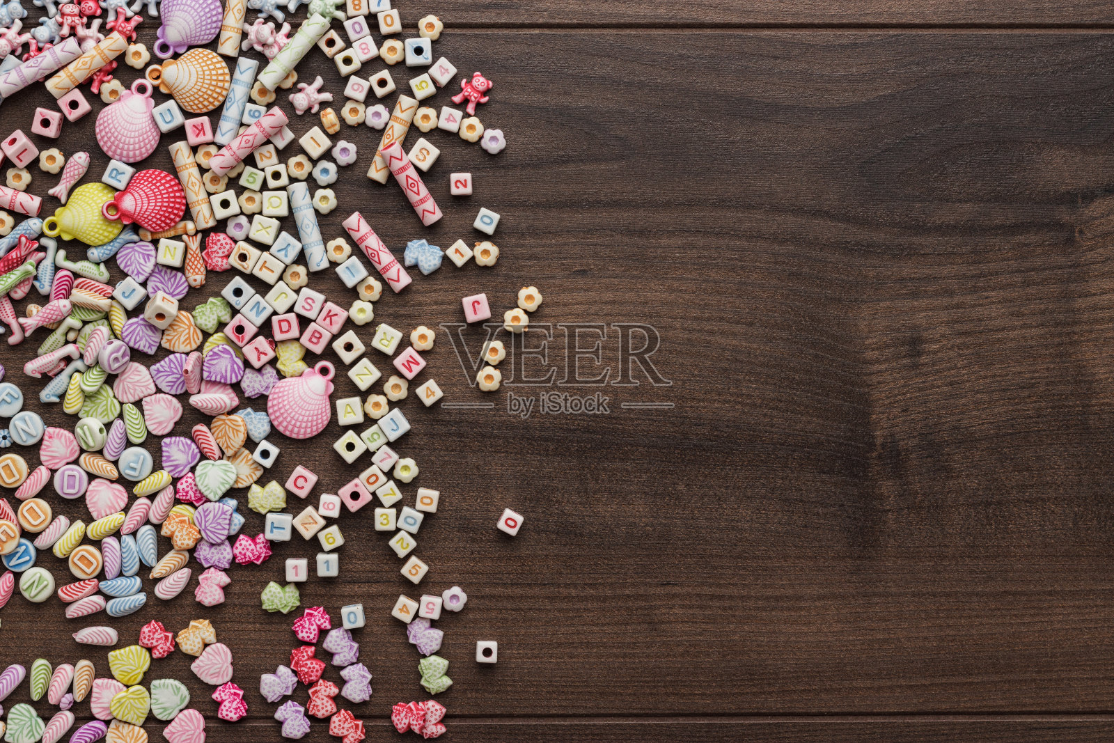 棕色的木桌上放着不同颜色的珠子照片摄影图片