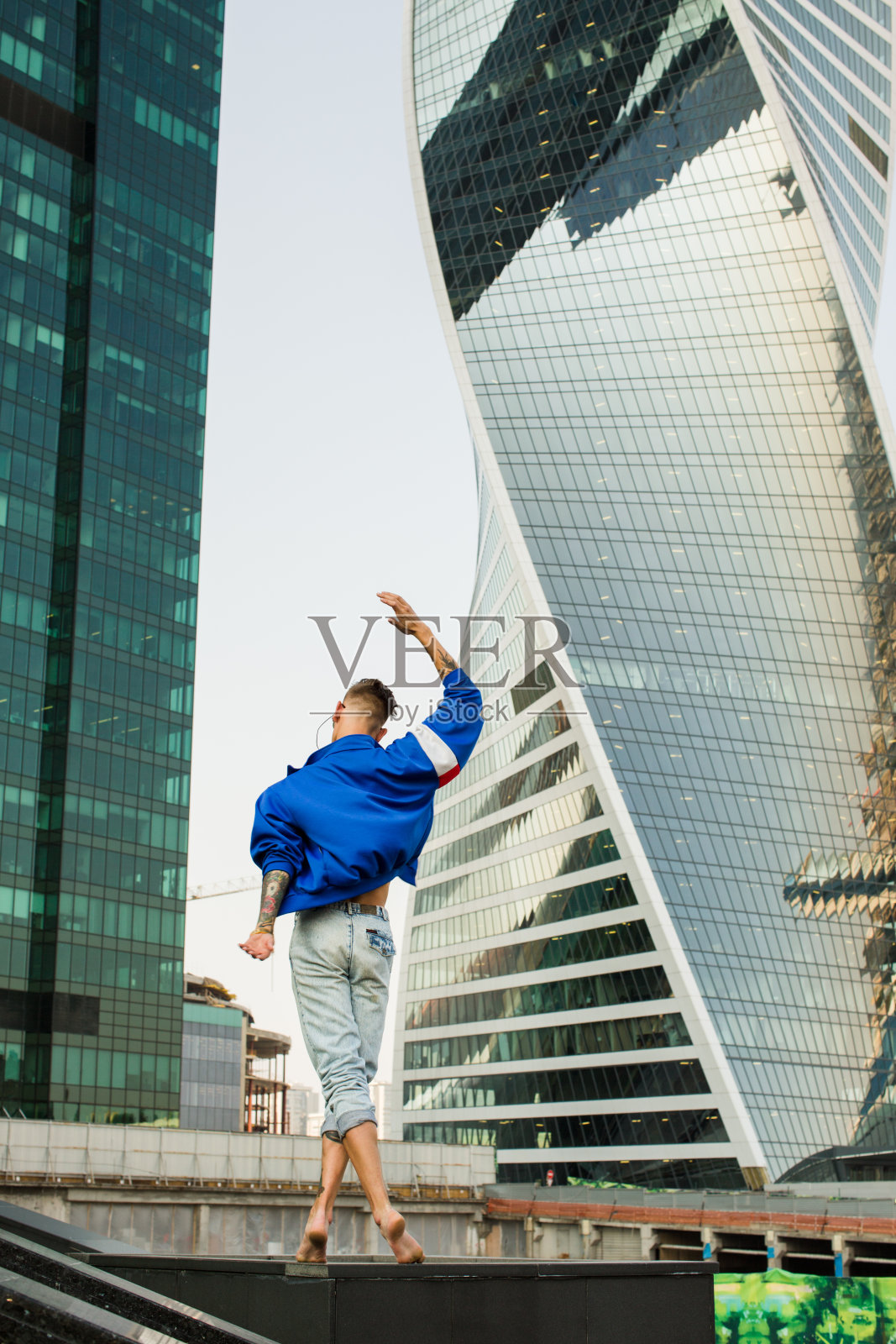 纹身男子在摩天大楼的背景上跳舞照片摄影图片